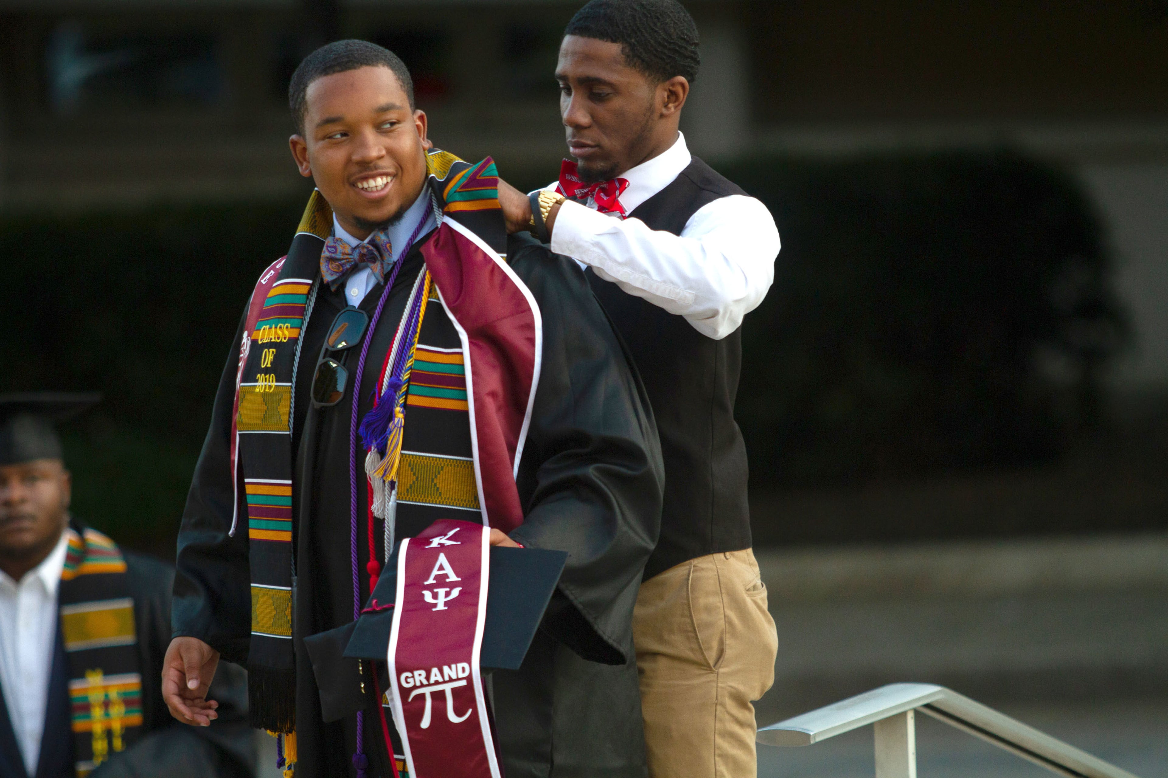 Jordan Reaves helps Christopher McCullough get ready for graduation before the start of the Morehouse College commencement in Atlanta on Sunday, May 19, 2019. STEVE SCHAEFER / SPECIAL TO THE AJC