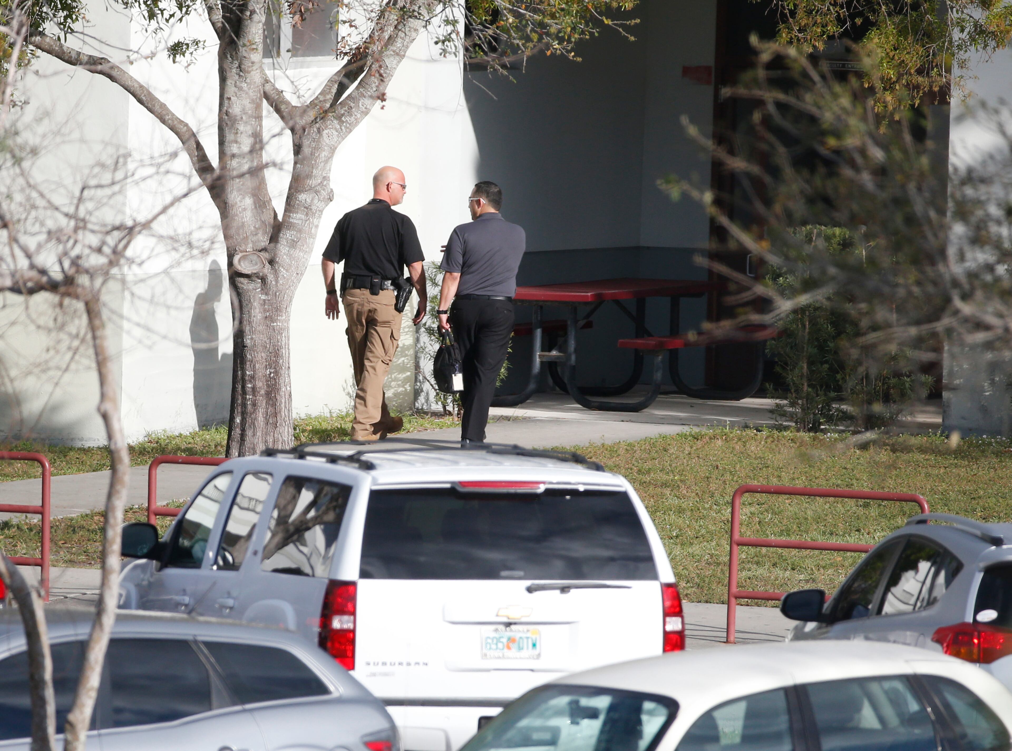 Law enforcement officers enter Marjory Stoneman Douglas High School, Thursday, Feb. 15, 2018 in Parkland, Fla. Nikolas Cruz was charged with 17 counts of premeditated murder on Thursday, the day after opening fire with a semi-automatic weapon at the school. (AP Photo/Wilfredo Lee)
