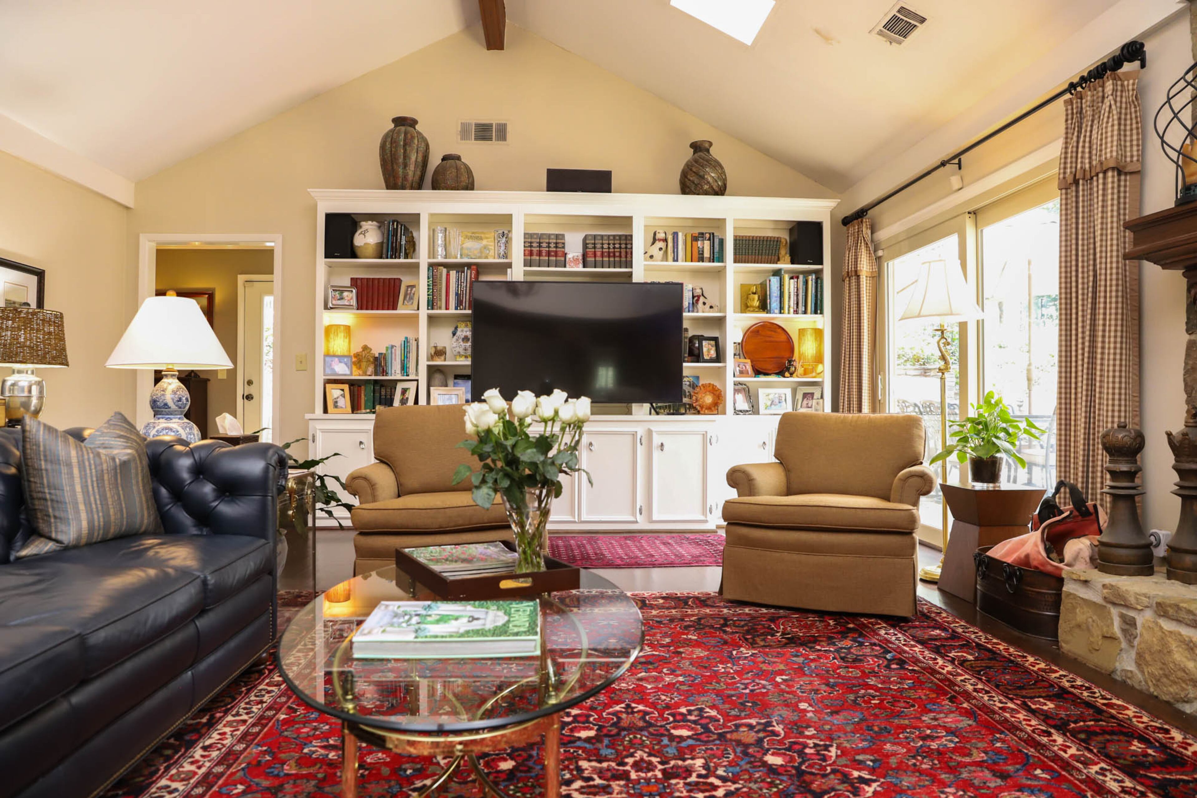 A navy leather sofa from Hancock and Moore Furniture and gold club chairs from Century Furniture make up a cozy sitting area in the family room of Jane and John Hall’s home. The family room is open to the kitchen, making it easy for the couple to visit with family and friends when they have guests over for a meal. The Oriental rug in the family room is one of several that Jane inherited from her father. Text by Shannon Dominy/Photo by Reynolds Rogers