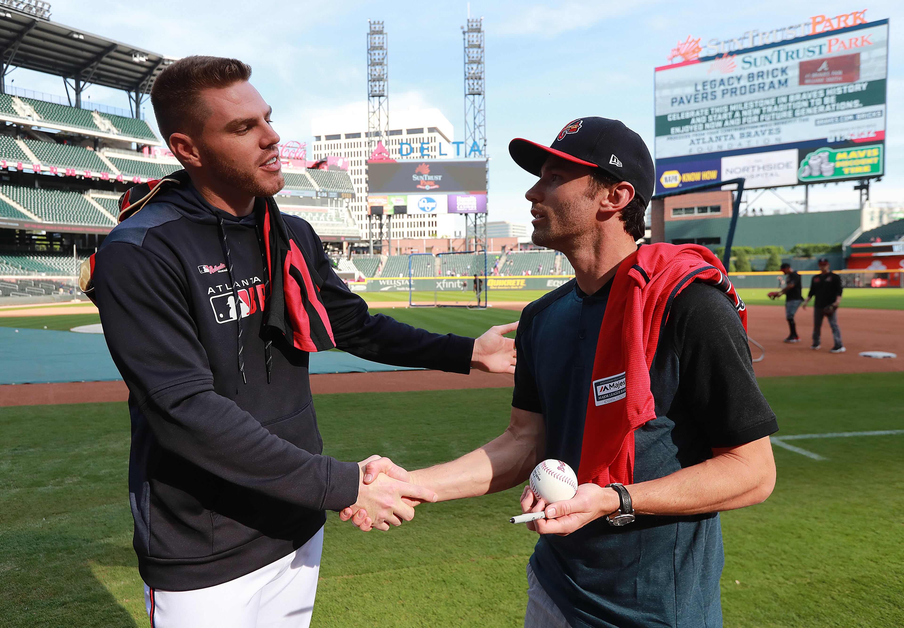 Braves' Freddie Freeman autographs a baseball for Atlanta United player Michael Parkhurst after exchanging jerseys before playing the Arizona Diamondbacks. The Braves honored Atlanta United for winning the MLS Cup. Curtis Compton/ccompton@ajc.com