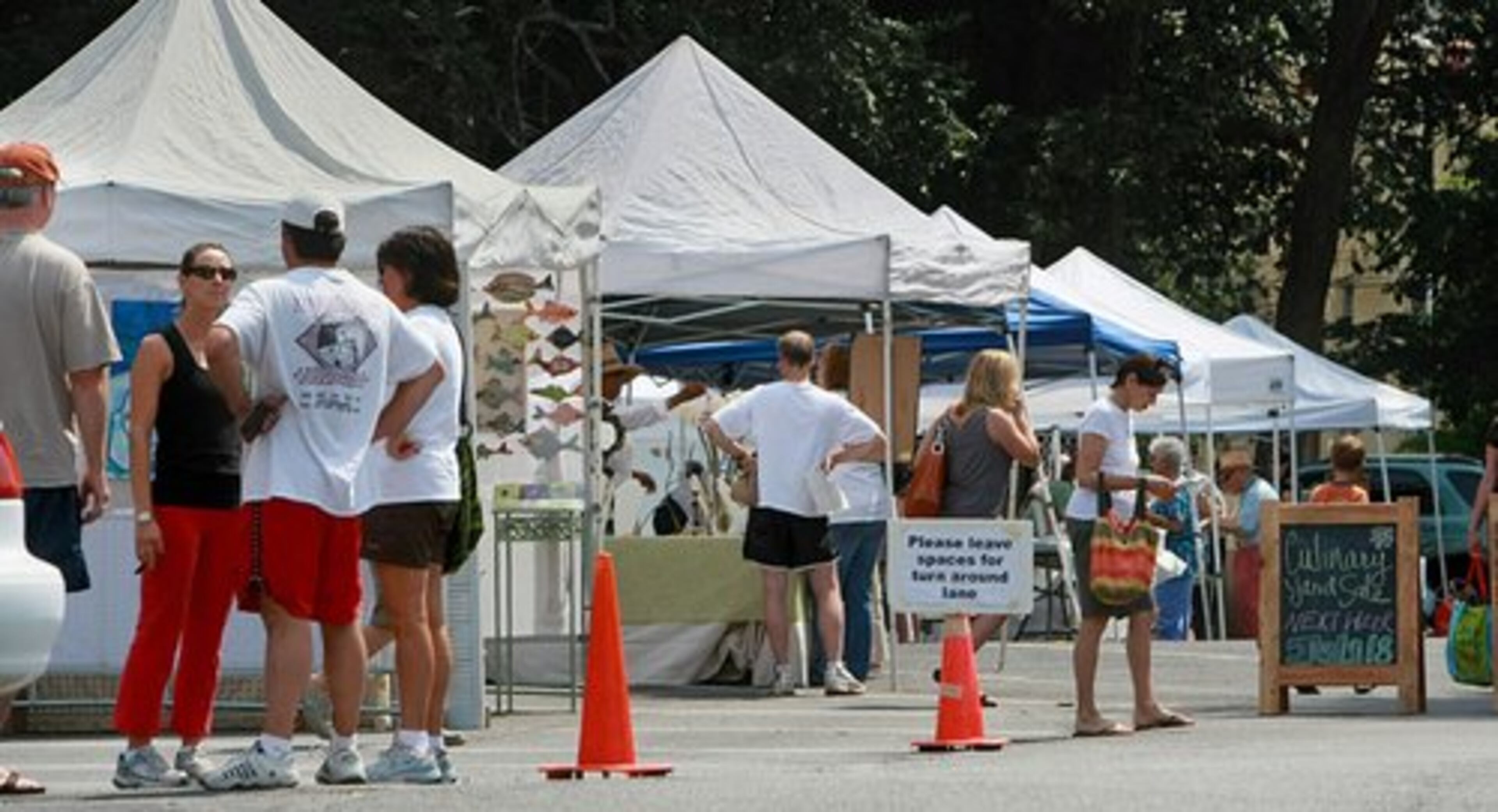 Produce and art shoppers peruse the wares of The Peachtree Road Farmers Market at the Cathedral of Saint Philip on Saturday.