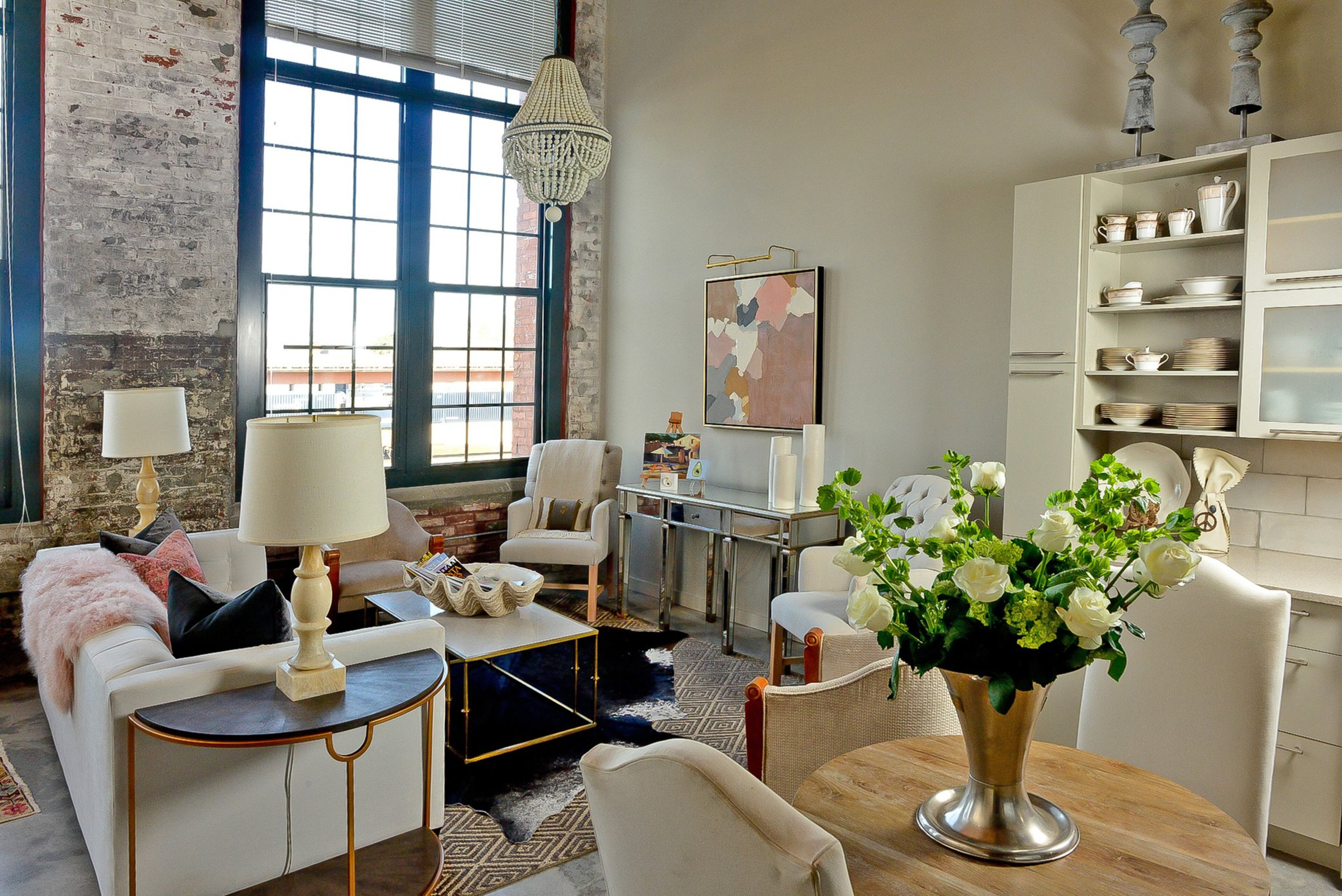 Andrea Costa collaborated with Kat Nelson of Kat Nelson Designs and Brenda Jones with Thrive and Design for her Atlanta loft’s hip casual and chic style. The chandeliers are from Regina Andrew Design and the sofa and coffee table are from Gregory Joseph Designs/Westside Market. The artwork over the mirrored console table is her own work.