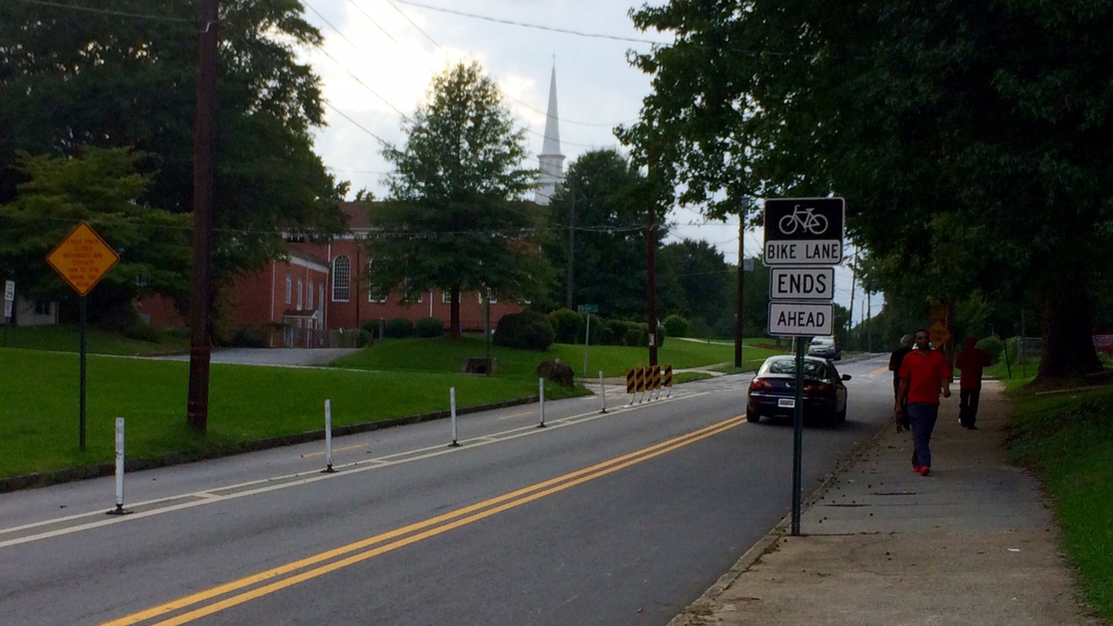 A sign warns bicyclists that a protected bike lane is about to end. A church in Atlanta requested removal of some of the lanes, saying they obstructed the congregation driving in and out. Others saw it as a sign of gentrification. (Photo by Bill Torpy)