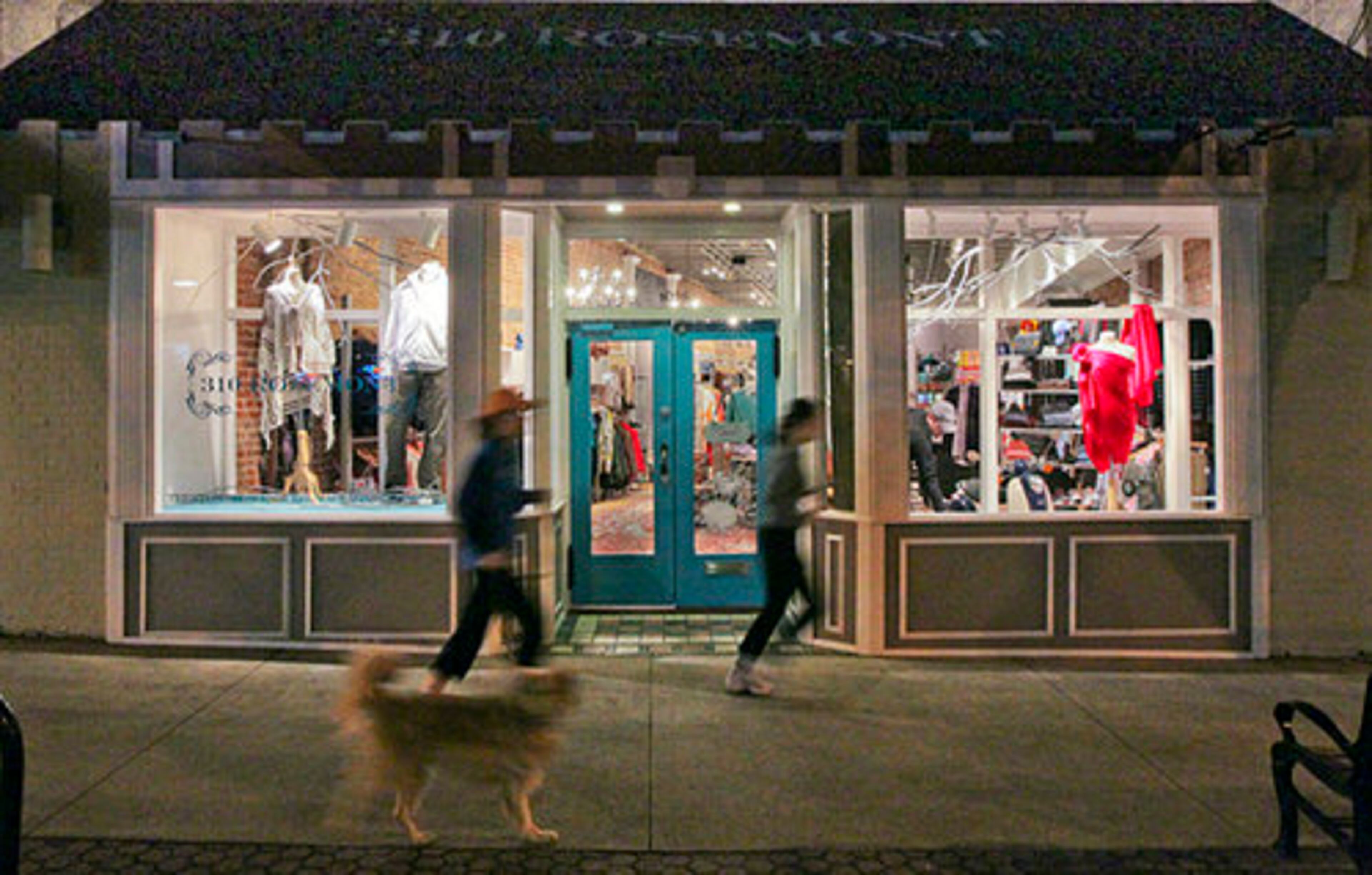 Joggers run by the damaged store front.