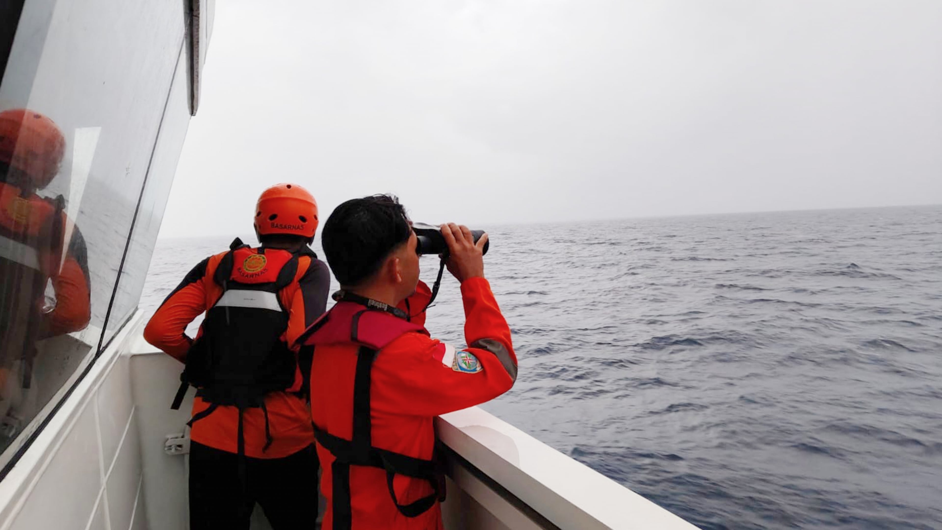 In this photo released by Makassar Search and Rescue Office on Sunday, July 19, 2026, rescuers scan the horizon as they search for victims after a passenger boat sank in the waters near Selayar Islands in South Sulawesi, Indonesia. (Makassar SAR Office via AP)