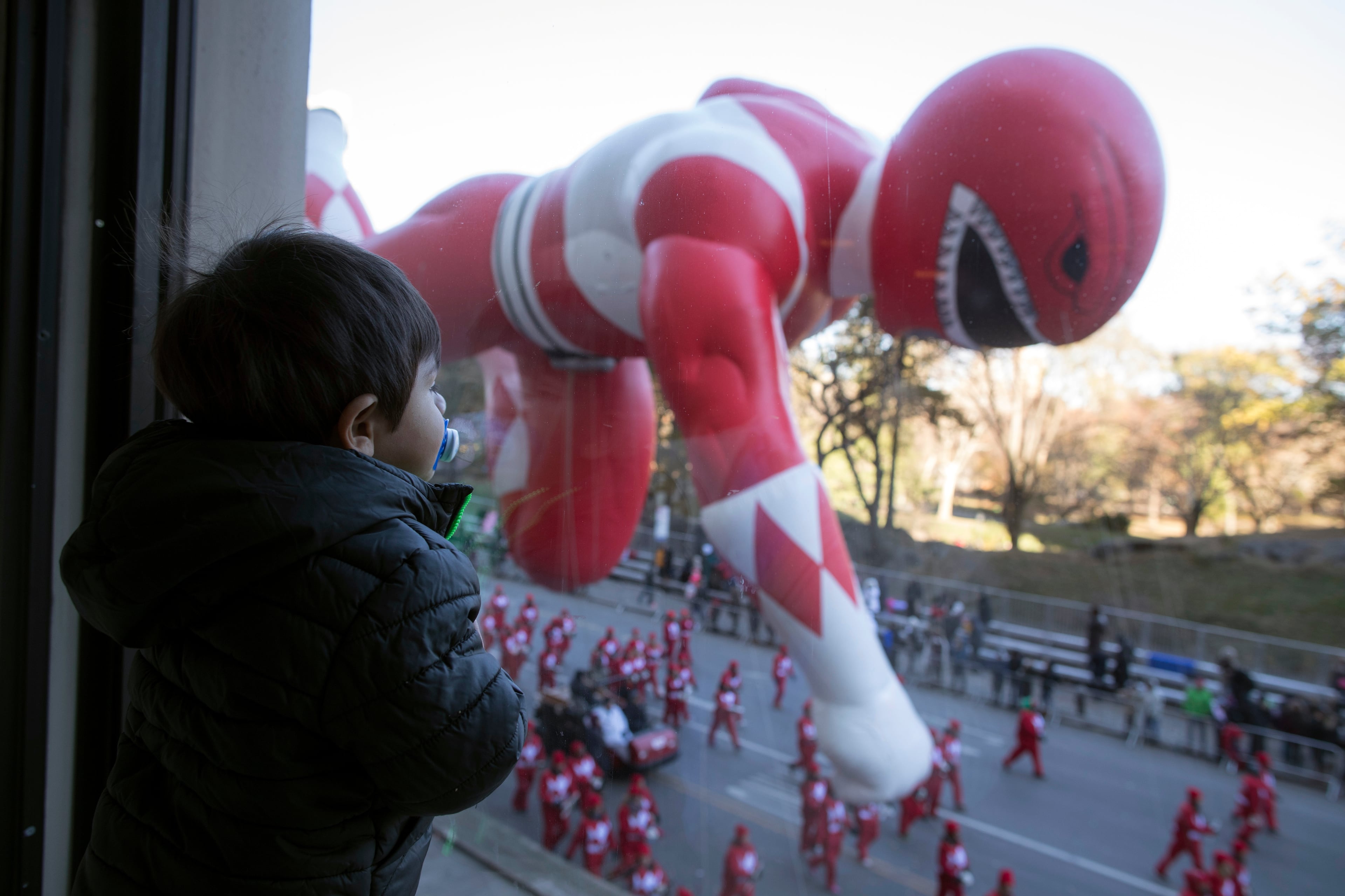 Hudson Garber, 2, watches the Red Mighty Morphin Power Ranger balloon floats by from the JW Marriott Essex House during the 92nd annual Macy's Thanksgiving Day Parade, Thursday, Nov. 22, 2018, in New York. (AP Photo/Mary Altaffer)