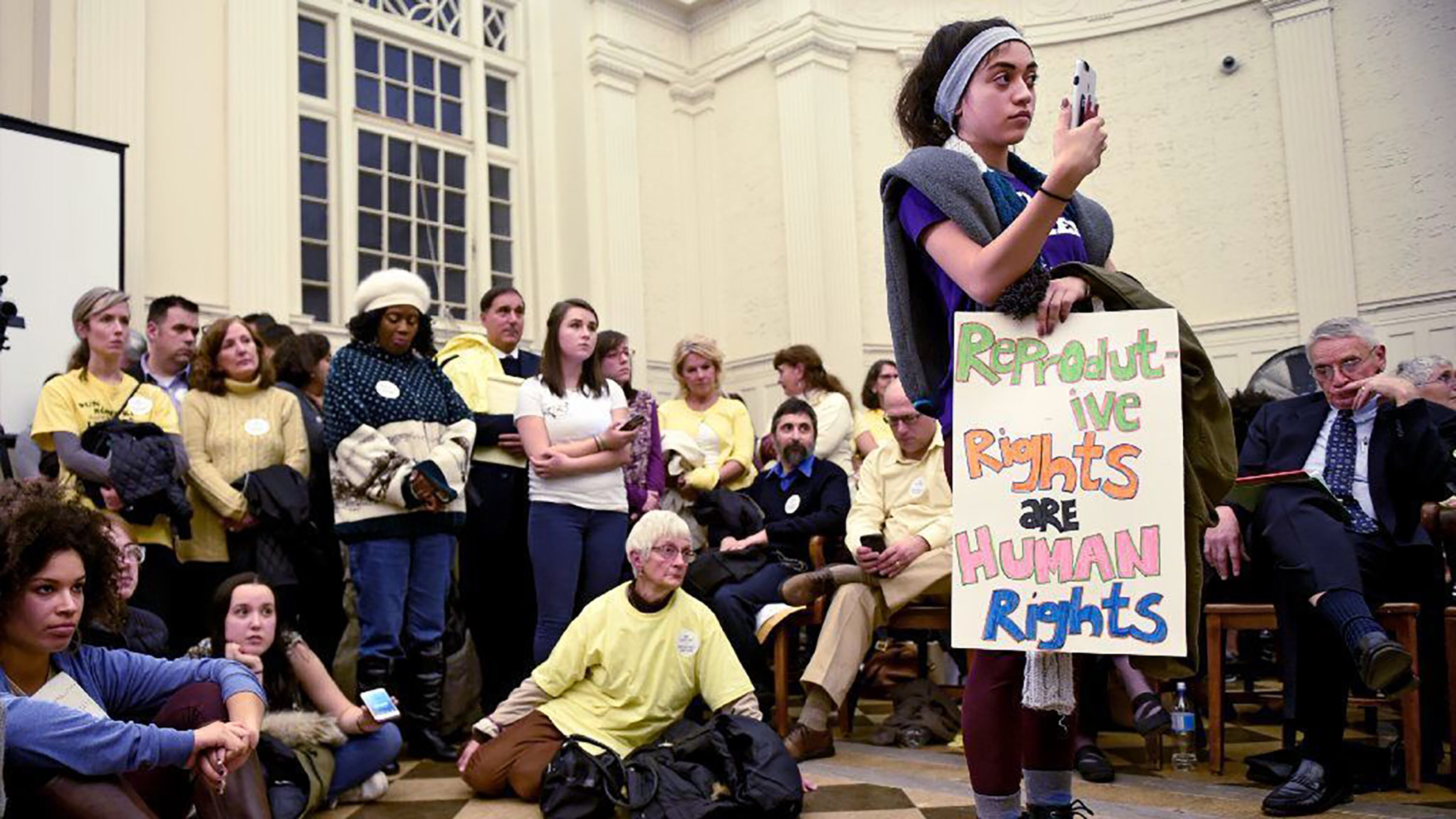 In this 2017 photo, Gragiela Valencia, a then-sophomore at Trinity College, was one of many students that attended a crowded council meeting at city hall as Hartford sought to crack down on faith-driven crisis pregnancy centers, which critics say sometimes pose as clinics to lure women and hand out misleading information about abortions. In 2022, $2 million in public funds was allocated to the 89 crisis pregnancy centers in Georgia. (John Woike/Hartford Courant/TNS)