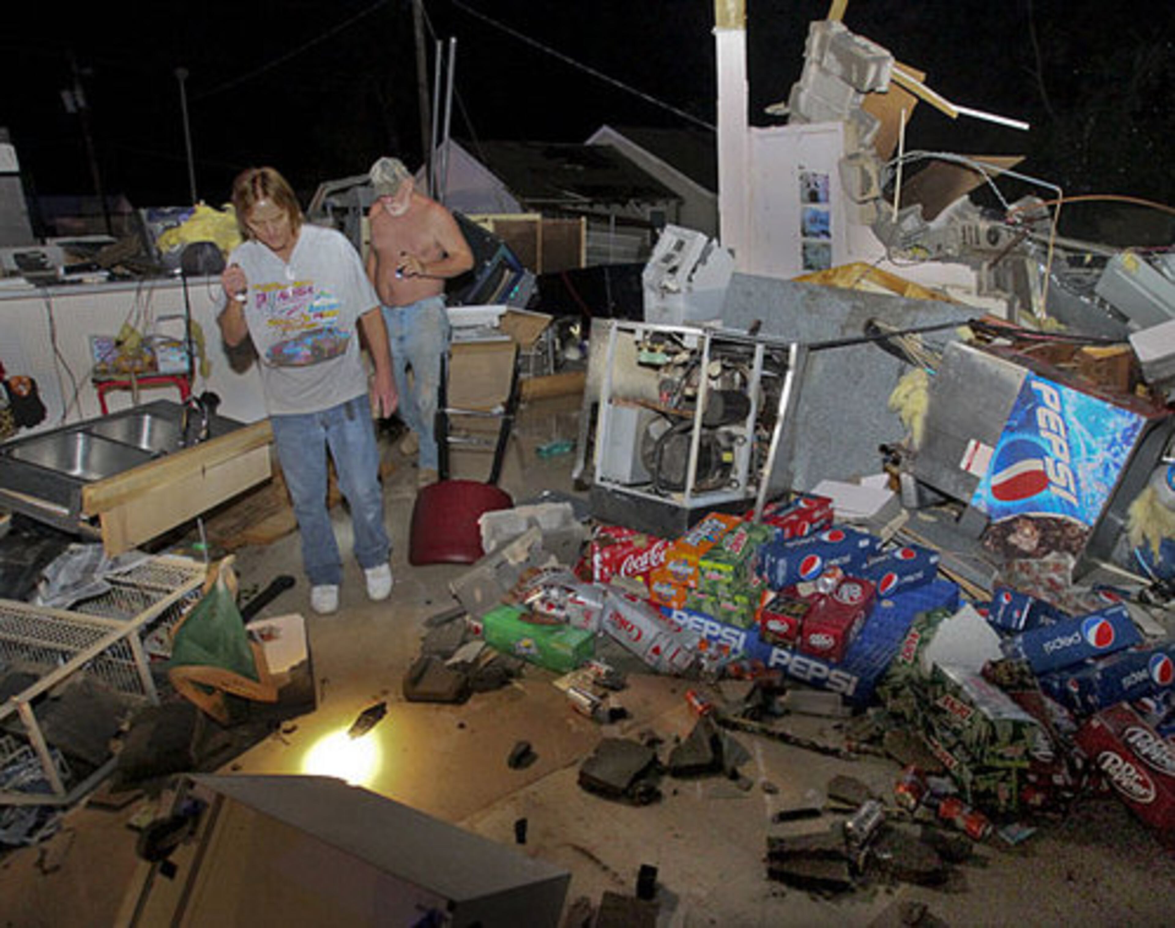 Owner of the Shell Station, Roy Brown (left) and Tim Bennett remove important items from his convenience store.