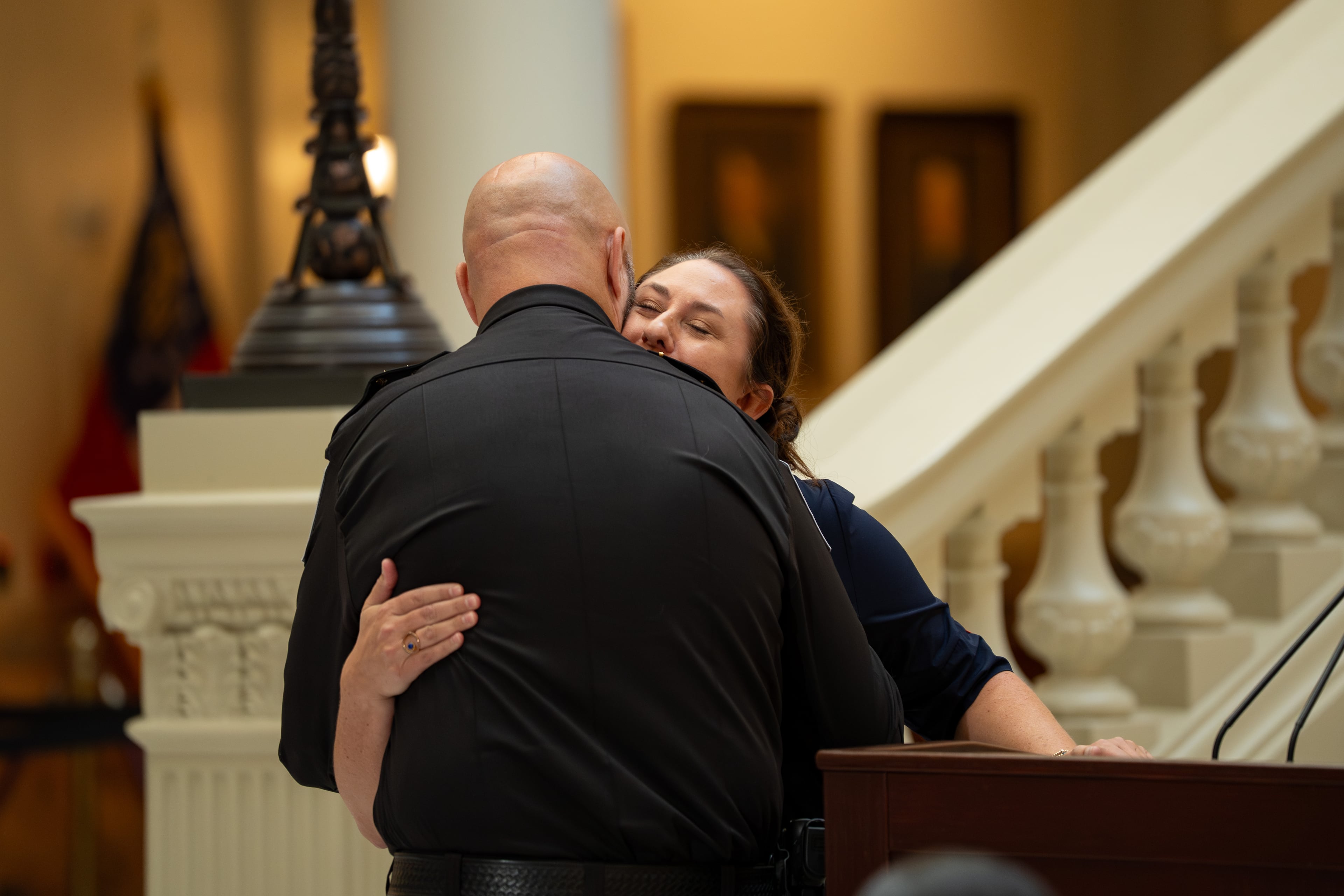 Apalachee High School principal Jessica Rehberg hugs Barrow County Sheriff Jud Smith at a ceremony at the Capitol declaring Sept. 4 as Apalachee Remembrance Day. (Ben Hendren for the AJC)