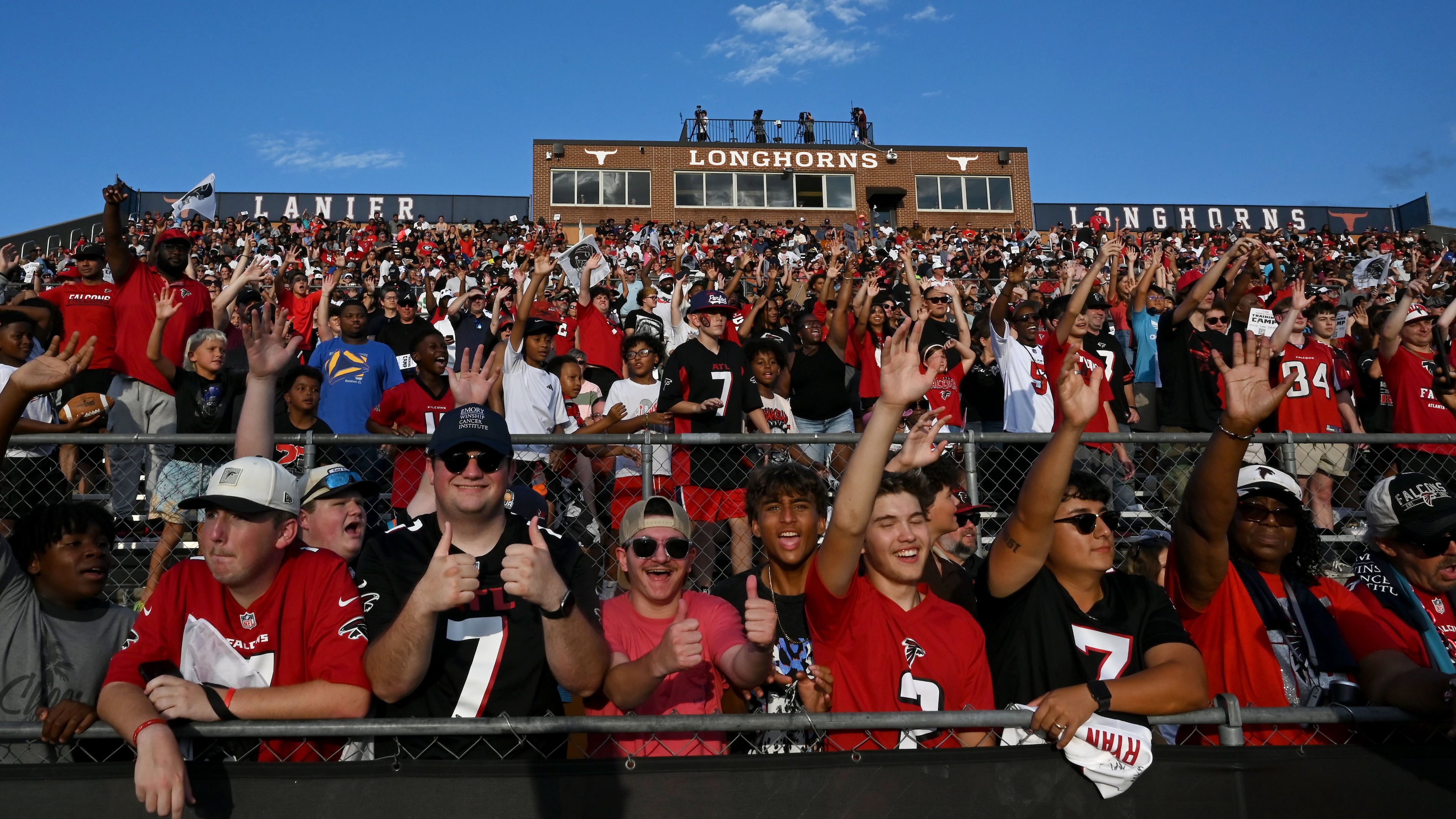Football fans cheer as they watch the Falcons' "Saturday Night Lights" practice at Lanier High School on Saturday, Aug. 8, 2026, in Sugar Hill. (Hyosub Shin/AJC)