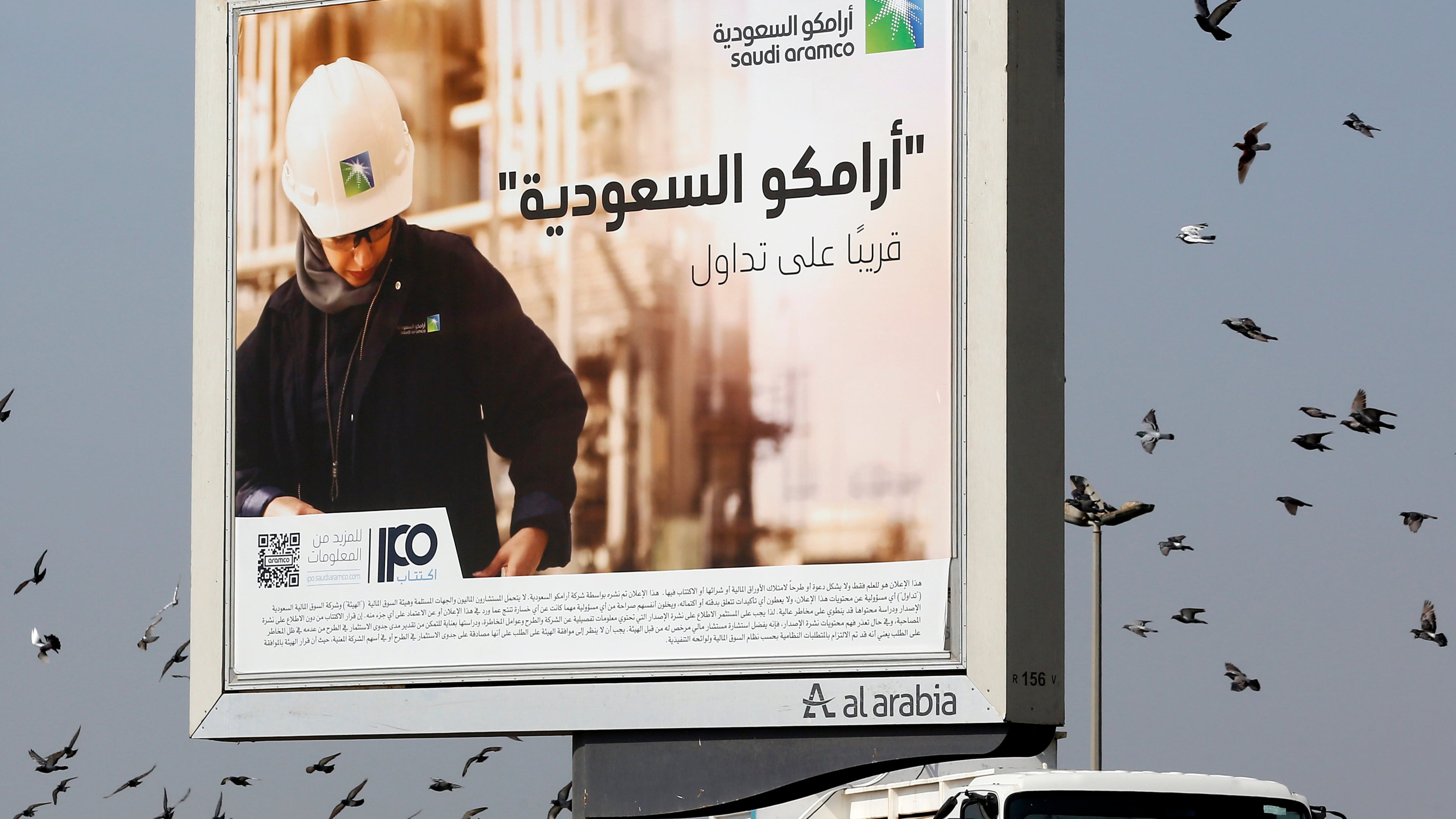 FILE -Birds fly over a billboard advertisement for Saudi Arabia's state-owned oil giant Aramco, with Arabic that reads, "Saudi Aramco, soon on stock exchange," in Jiddah, Saudi Arabia. (AP Photo/Amr Nabil, File)