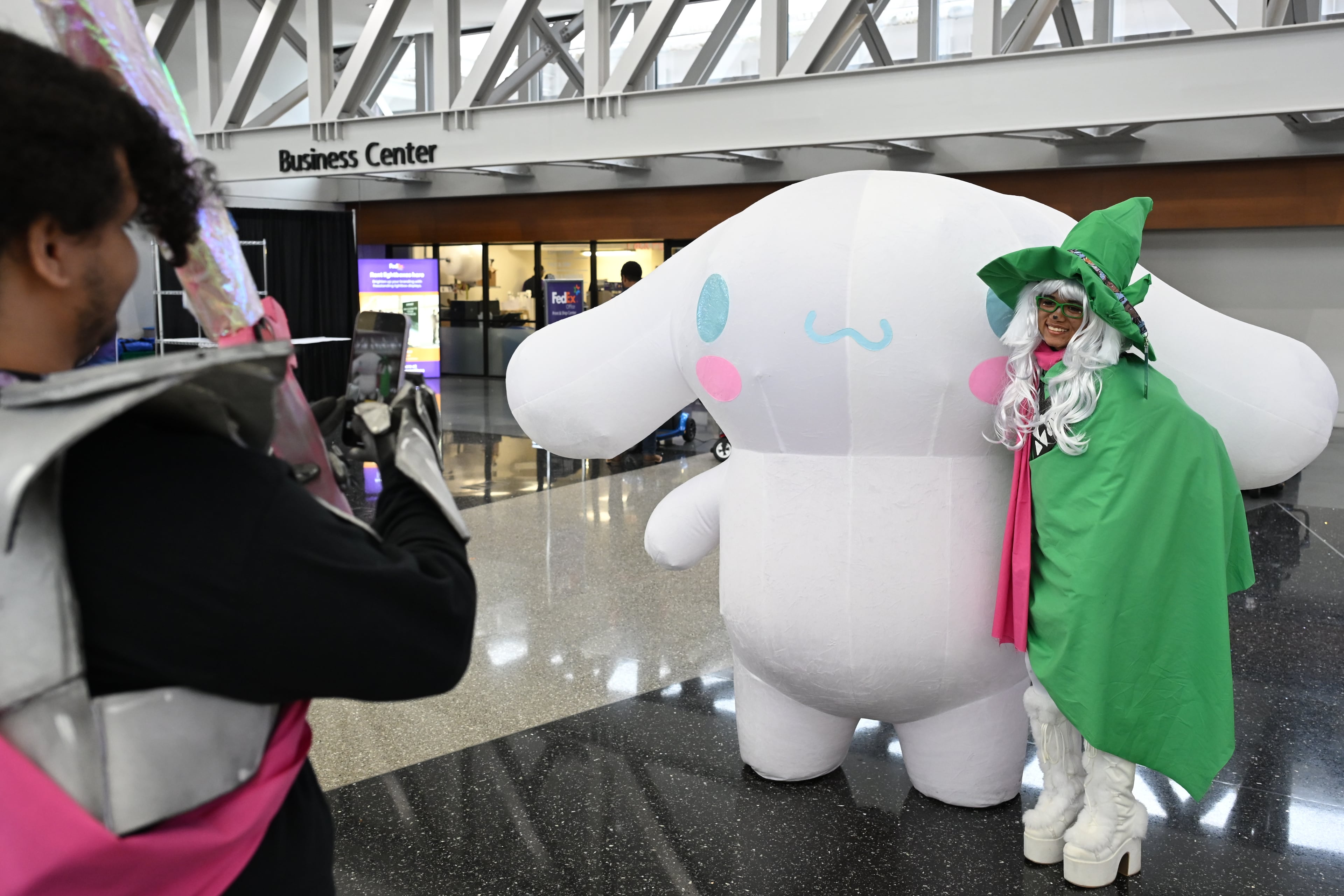 An attendee takes a photo with another attendee, dressed as Cinnamoroll, during MomoCon at the Georgia World Congress Center in Atlanta on Friday, May 22, 2026. (Tyler Sun for the AJC)