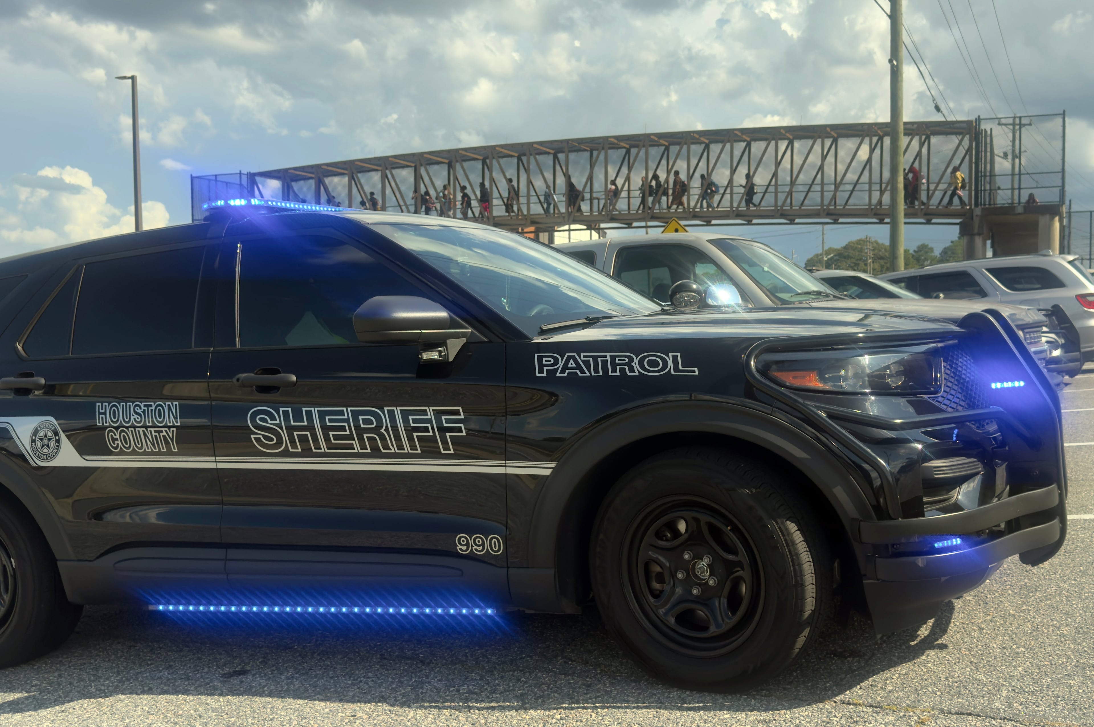 Students leave Warner Robins High School as Houston County Sheriff's vehicles remain on the scene after a shooting on campus left one injured at the Middle Georgia school on Aug. 12, 2026, officials said. Police have a suspect in custody. (Joe Kovac/AJC)