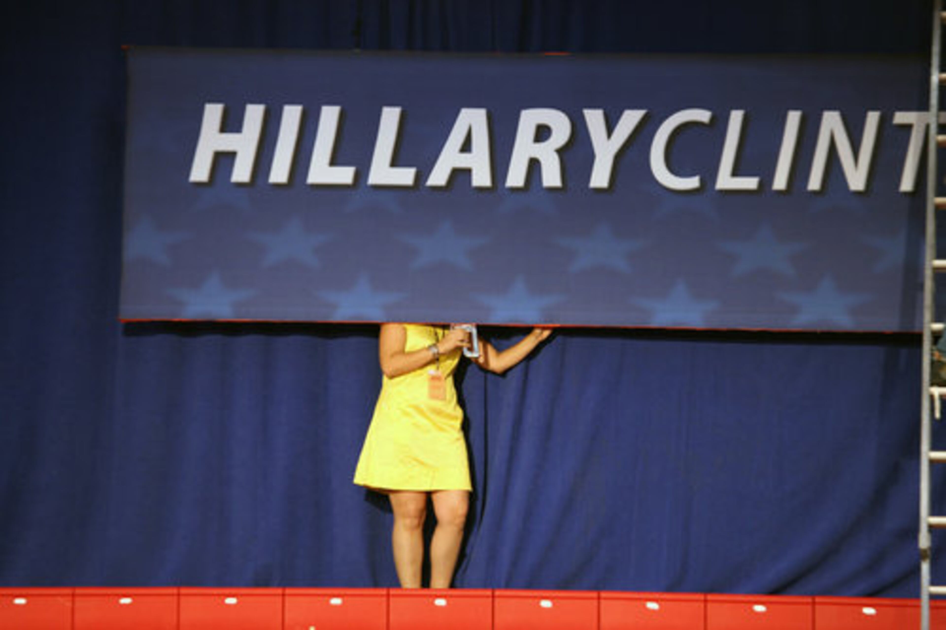 Armed with a staple gun, a Clinton campaign worker helps prepare for a rally at Baruch College in New York on Tuesday.