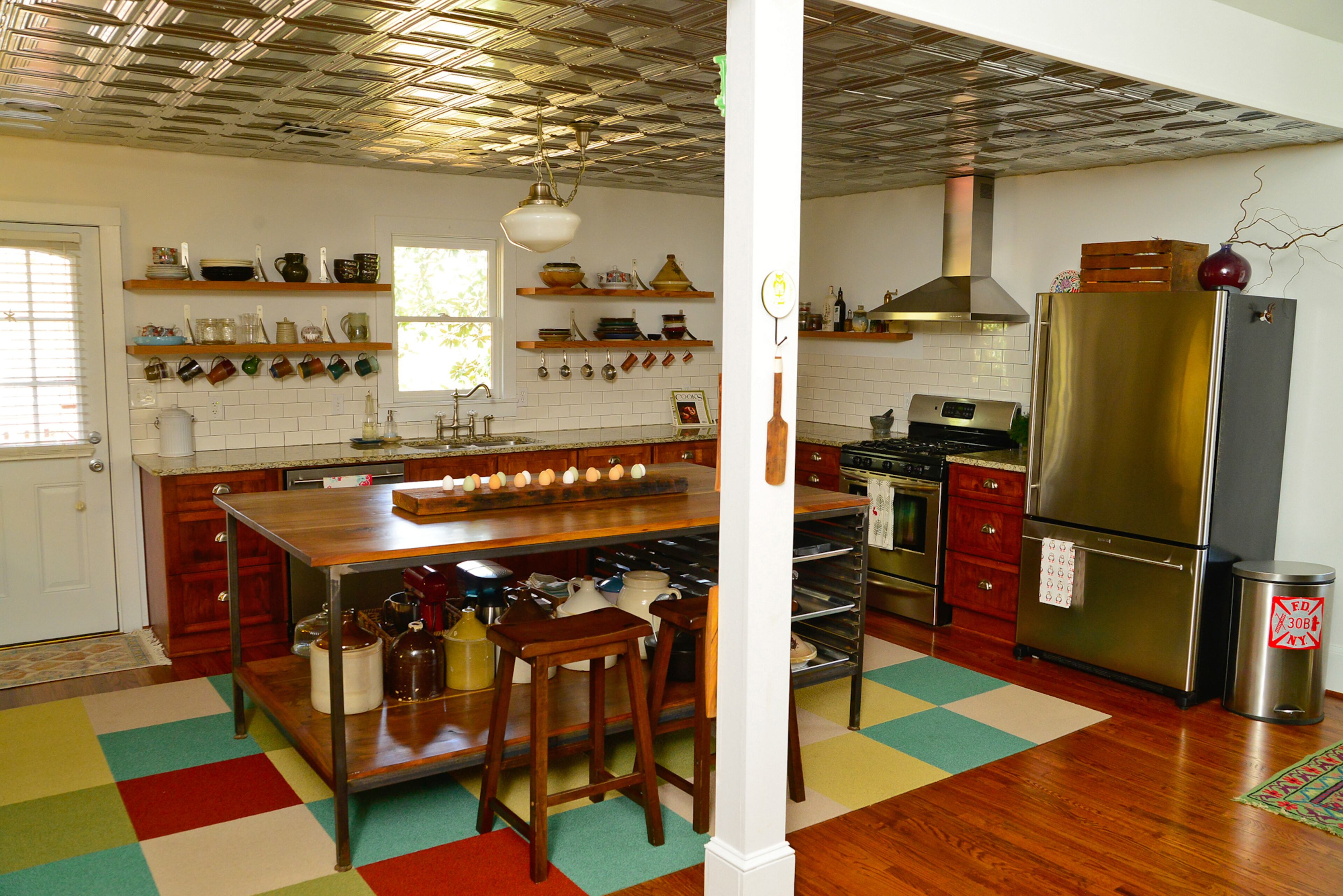 The kitchen was reconfigured when homeowners Eileen Ansley and Andrew Burnes moved into the 1927 East Atlanta home. They added the metal ceiling, island and removed the top shelves. The appliances are Jenn-Air and Frigidaire.