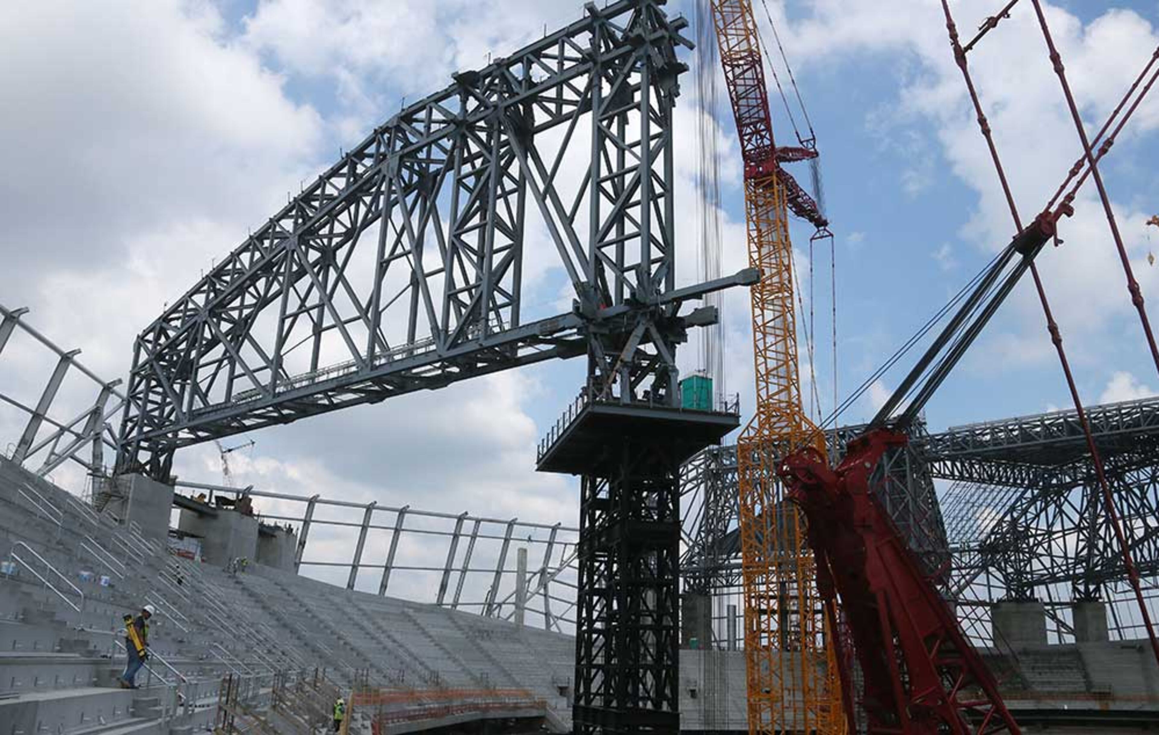 Roof steel trusses are visible as work continues on assembling and installing them.