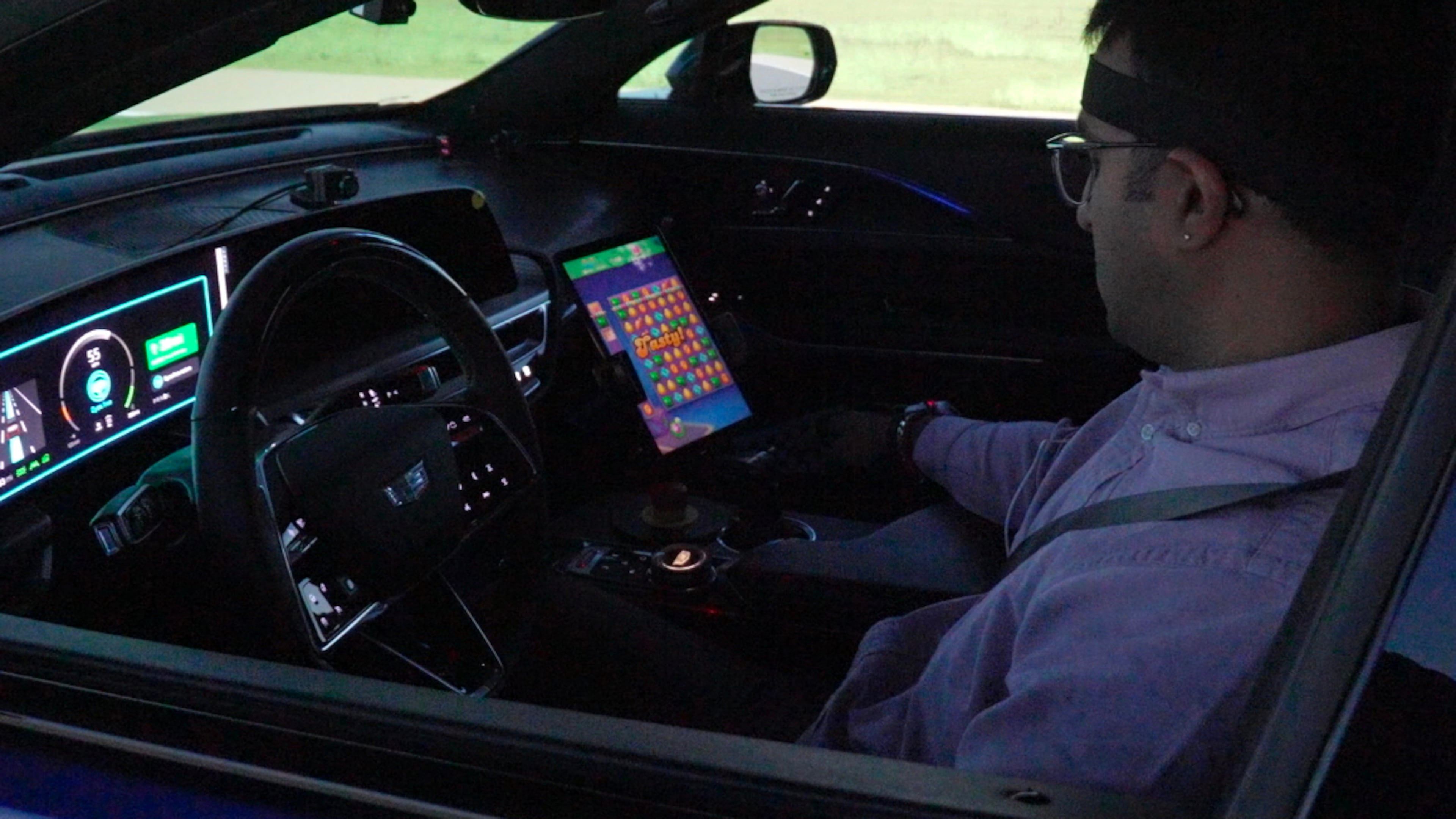 In this image from video, General Motors senior researcher Akilesh Rajavenkatanarayanan plays Candy Crush on a tablet mounted in a Cadillac Lyriq while it is in "eyes off" mode during a simulated drive at the automaker's Global Technical Center Friday, Sept. 18, 2026, in Warren, Mich. (AP Photo/Mike Householder)