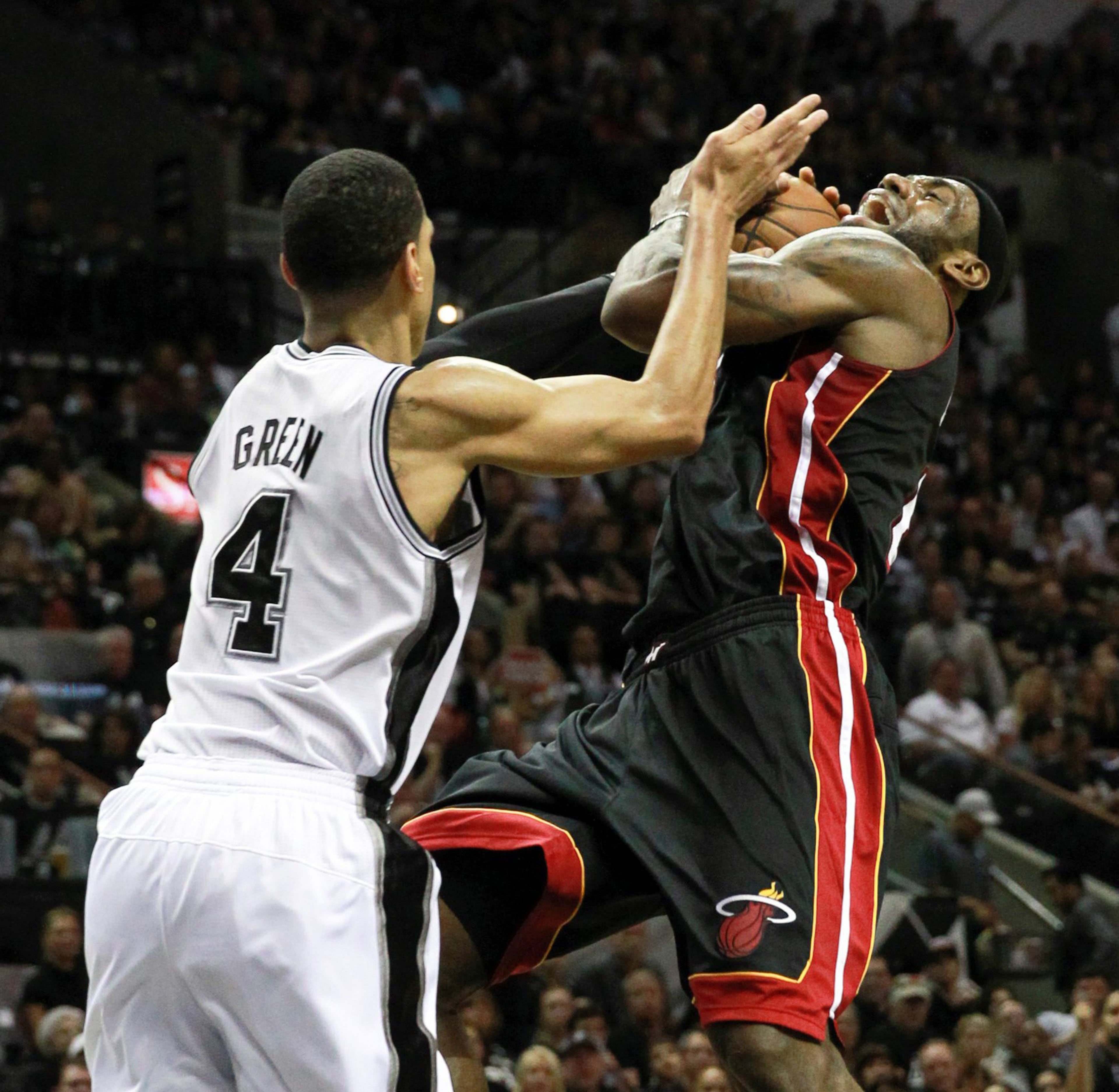 Miami Heat's LeBron James is stopped by San Antonio Spurs' Danny Green during the third quarter in Game 5 of the NBA Finals at the AT&T Center in San Antonio, Texas, Sunday, June 16, 2013.