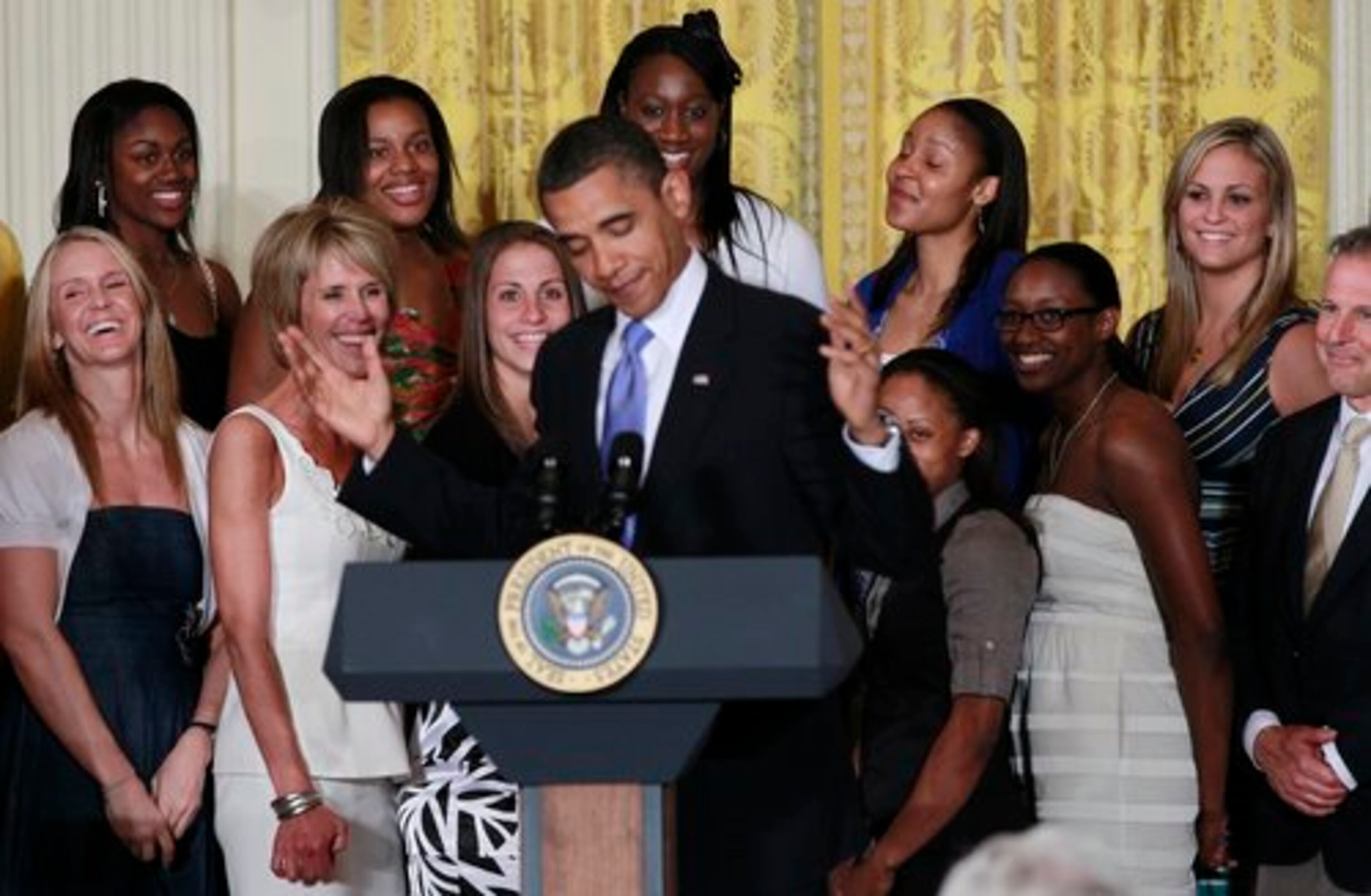 Team members laugh while the President makes a comment. Pictured rear center are Maya Moore (right) and Tina Charles.