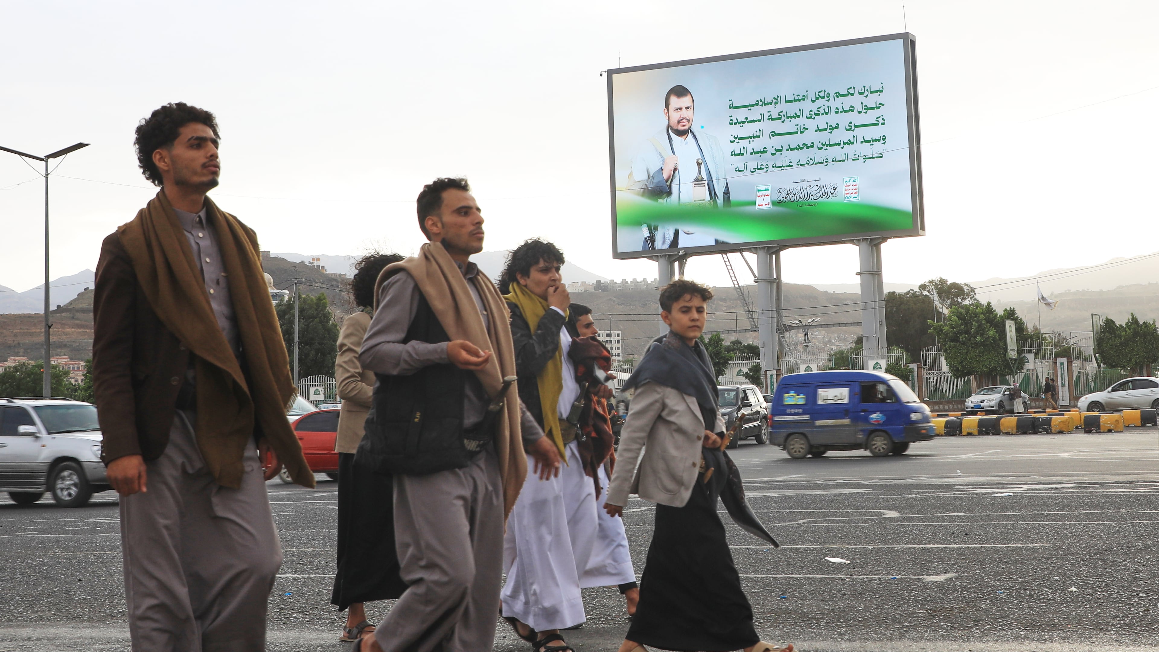 People walk under a billboard showing Houthi leader Abdul Malik al-Houthi with a phrase from the Islamic book Quran that reads in Arabic; "In the bounty of Allah and in His mercy - in that let them rejoice; it is better than what they accumulate" in Sanaa, Yemen, Sunday, Sept. 6, 2026. (AP Photo/Osamah Abdulrahman)