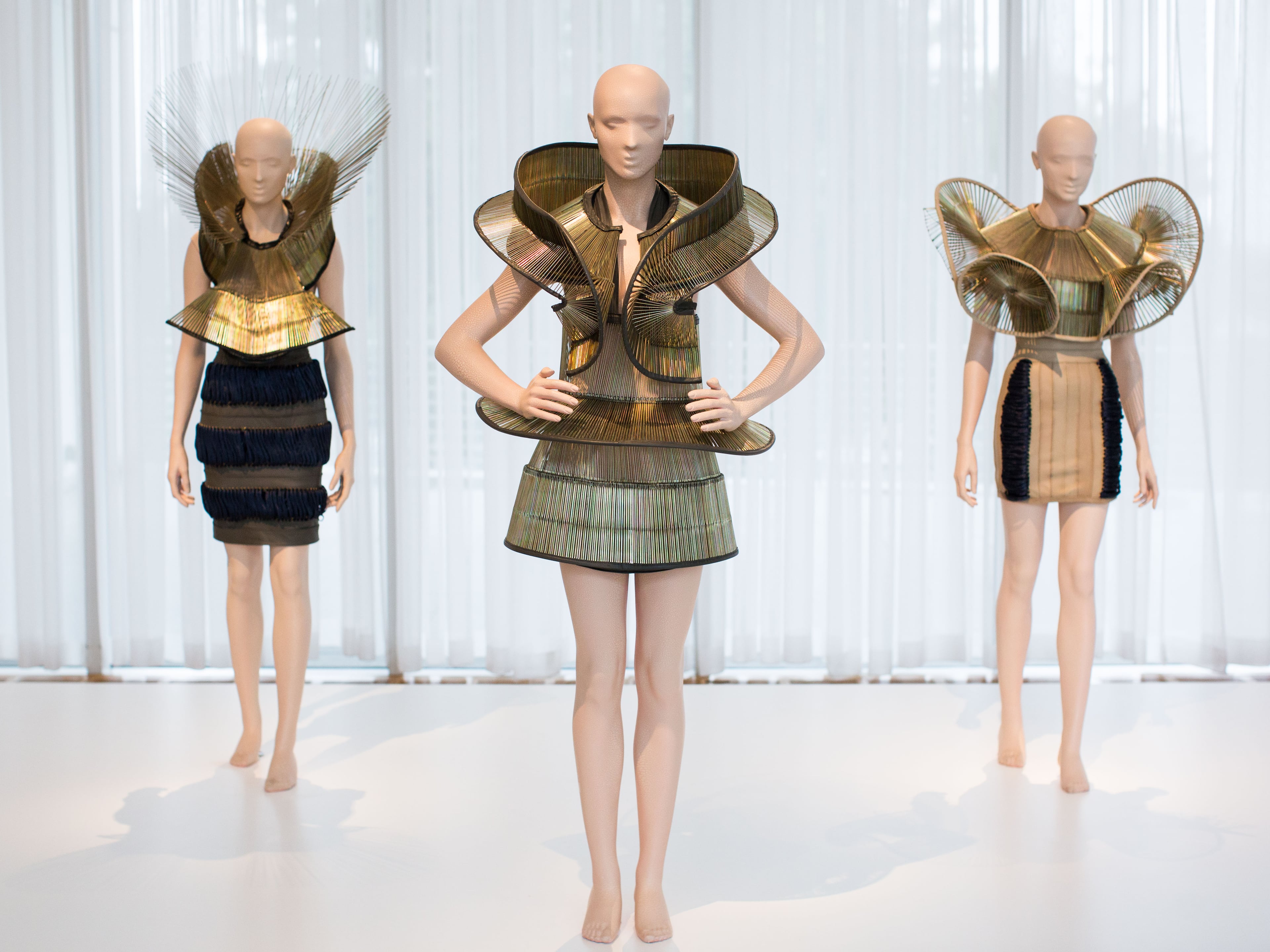 Dresses from the Chemical Crows collection by designer Iris van Herpen are displayed at the High Museum's new exhibit, "Iris van Herpen: Transforming Fashion,"Thursday, Nov. 5, 2015, in Atlanta. The exhibit, running through May 15, shows the evolution of van Herpen's design from collections created from 2008 through 2015. Van Herpen is known for creating high-tech fabrics and fashions that combine materials like steel and silk with everyday objects like magnets and umbrella parts. (AP Photo/Branden Camp)