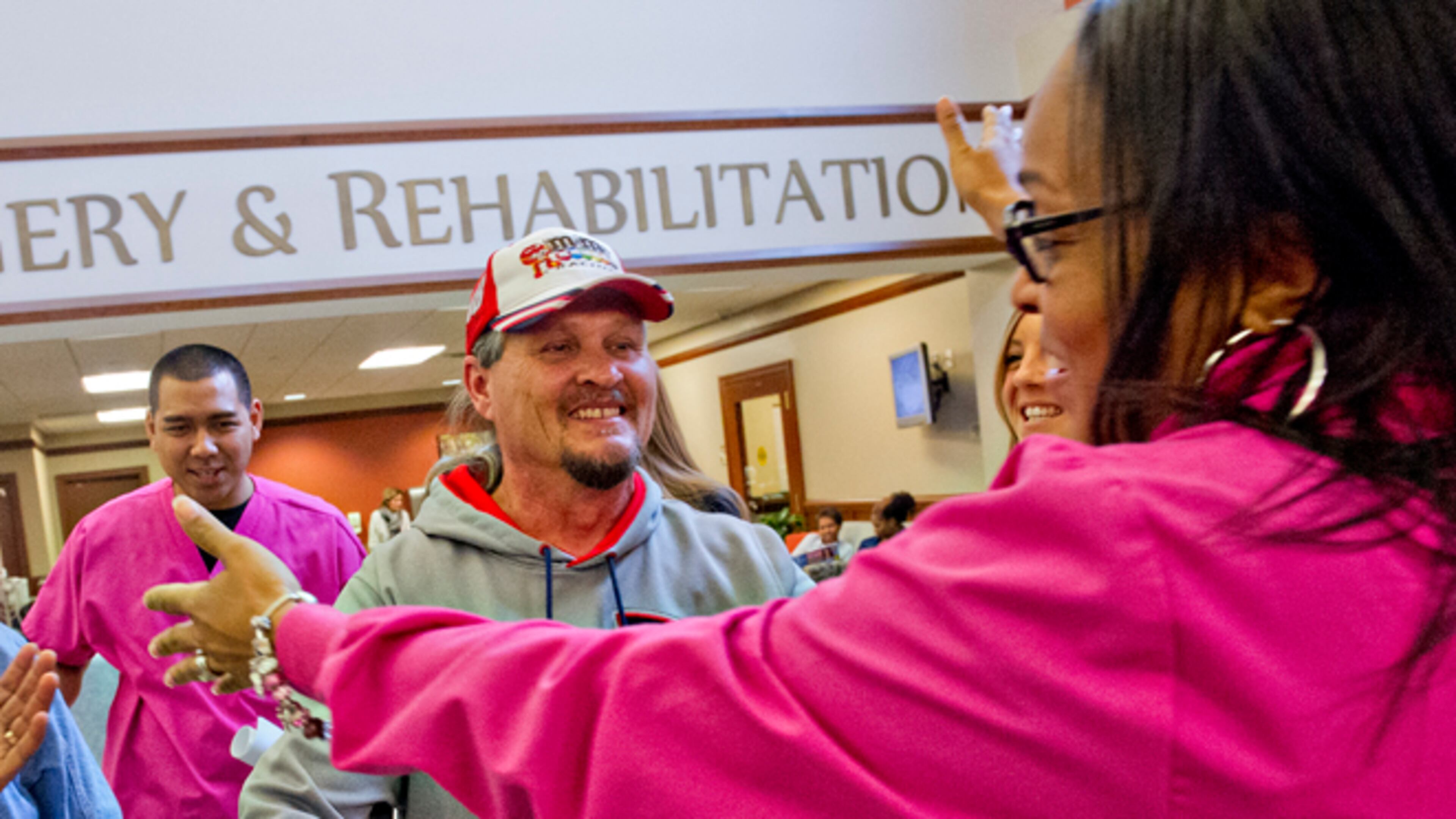 Ron Butler (center) is hugged by Jennifer Huff after receiving his final radiation treatment at the CancerTreatmentCenters of America's Southeastern Regional Medical Center in Newna.