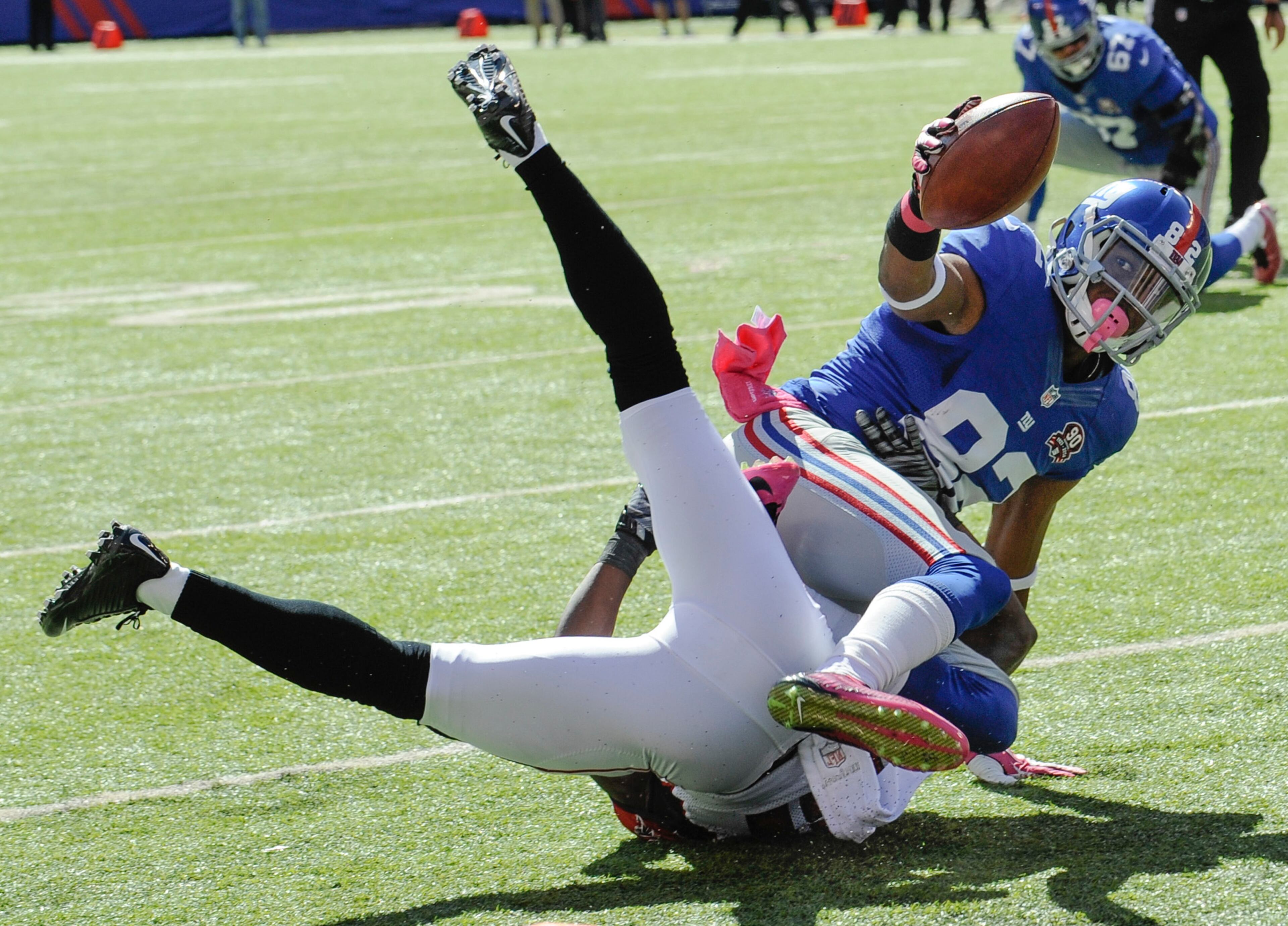 New York Giants wide receiver Rueben Randle (82) is tackled by Atlanta Falcons cornerback Desmond Trufant but scores on a touchdown pass from quarterback Eli Manning during the first half of an NFL football game, Sunday, Oct. 5, 2014, in East Rutherford, N.J. (AP Photo/Bill Kostroun)