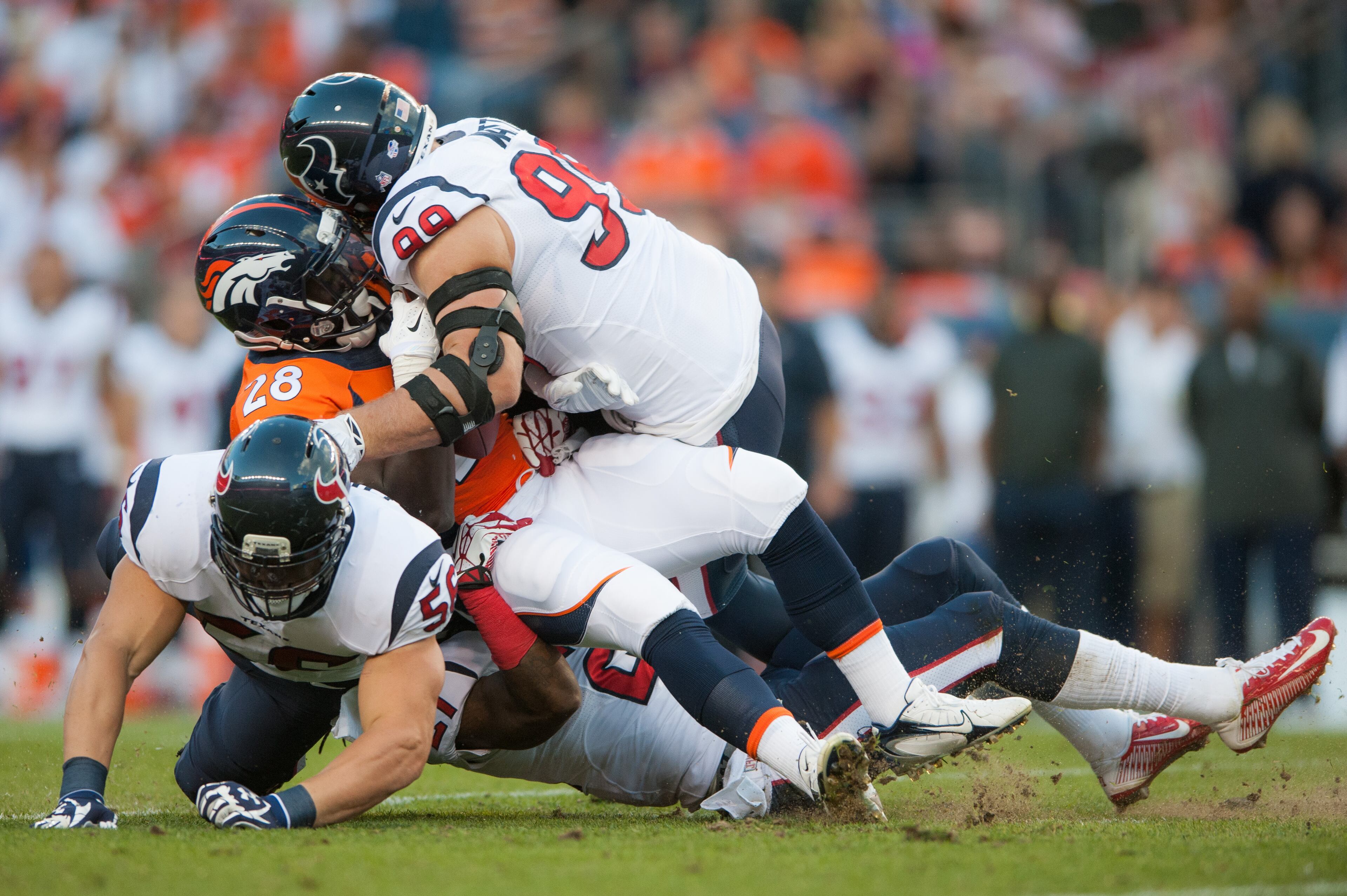 J.J. Watt (top) brings down Montee Ball of the Denver Broncos. (Photo by Dustin Bradford/Getty Images)