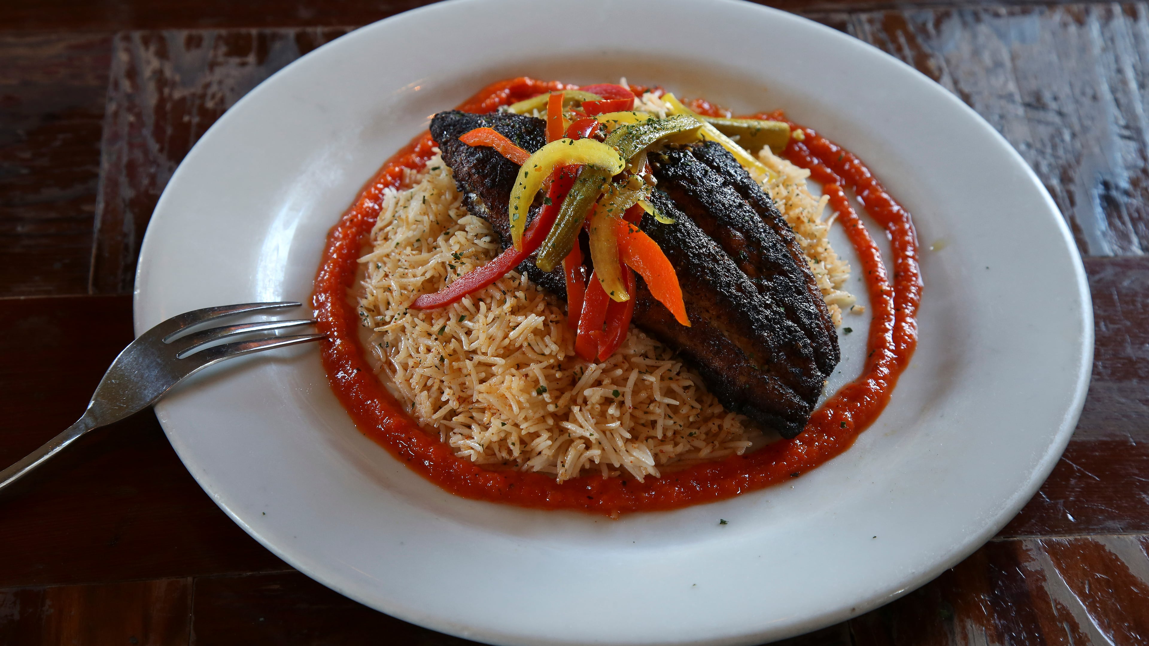 Blackened Catfish with roasted red pepper sauce and rice, served at Brown Sugar Kitchen in Oakland, Calif., Oct. 22, 2015. Chef Tanya Holland's “California-ized” renditions of African-American comfort food are just one example of how black chefs are reinventing and reinterpreting staid notions of soul food.