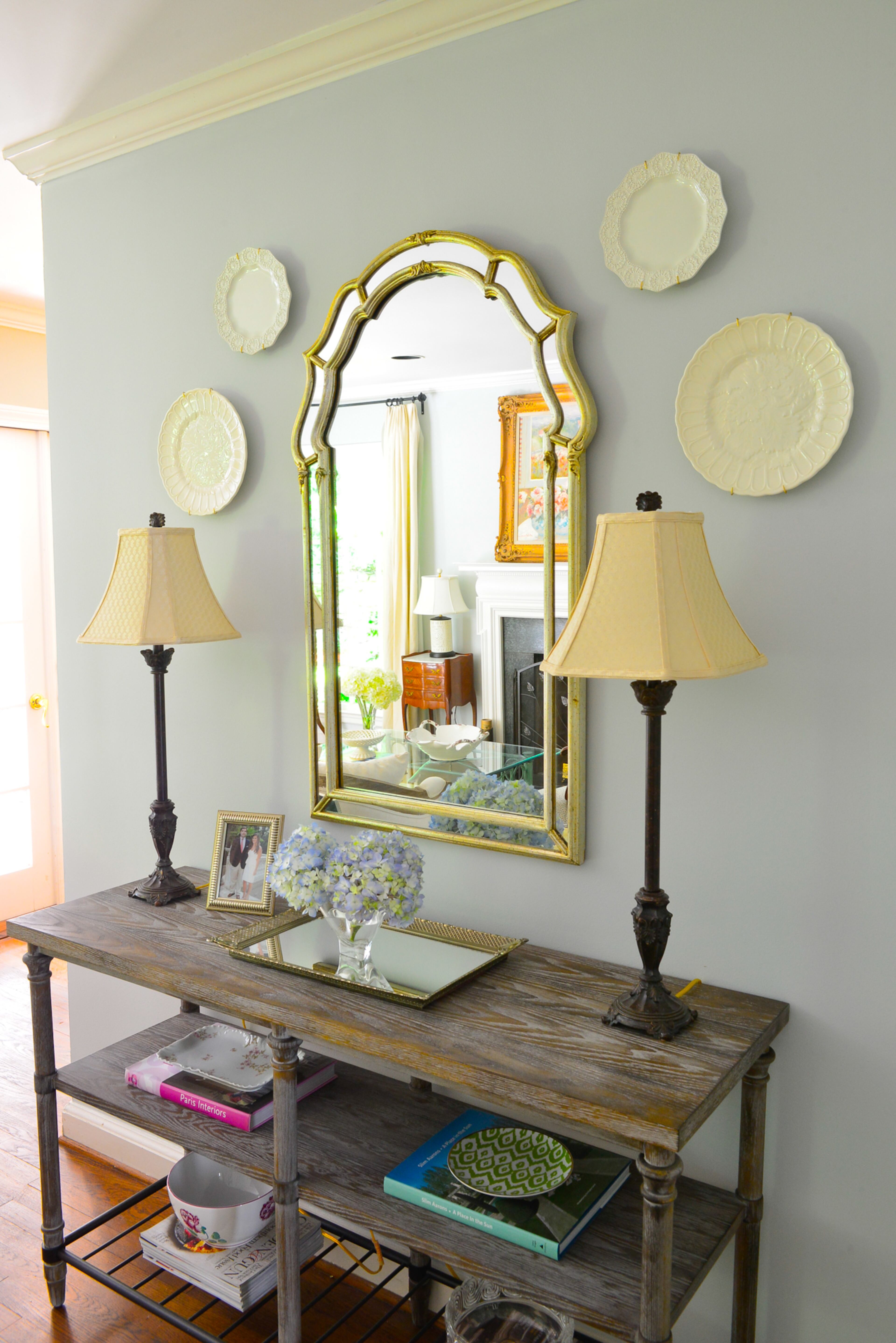 Creamware plates from 14th Street Antiques in Atlanta are positioned perfectly around a mirror passed down from homeowner Catherine Callaway's grandparents. The distressed wood console-style table is from Havertys.