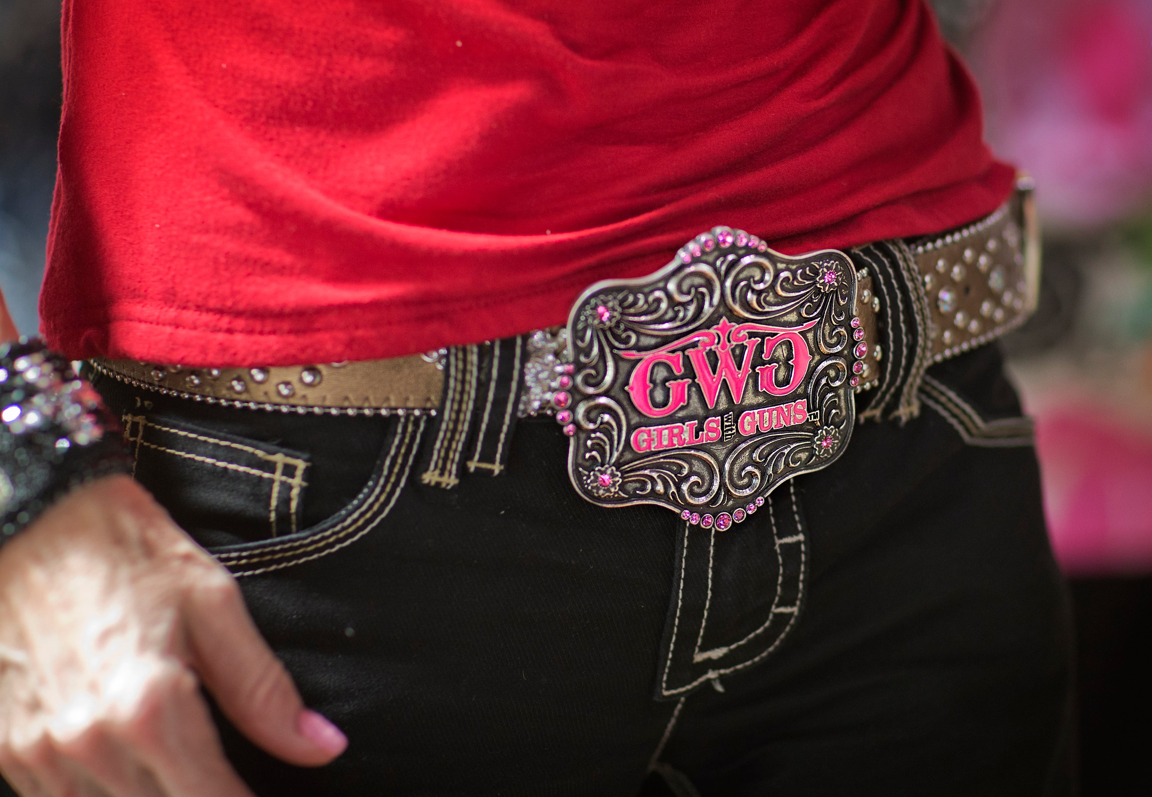 The belt buckle of former Alaska governor and 2008 Republican vice presidential nominee Sarah Palin, reads "Girls with Guns" as she greets attendees of a county women's group meeting to campaign for Republican candidate for U.S. Senate Karen Handel, right, Thursday, April 3, 2014, in Union City, Ga. Palin is riding to the defense of the only Republican woman in the nomination fight for Georgia's open Senate seat, hitting back against GOP rival David Perdue's apparent dismissal of Karen Handel's high school education. (AP Photo/David Goldman)