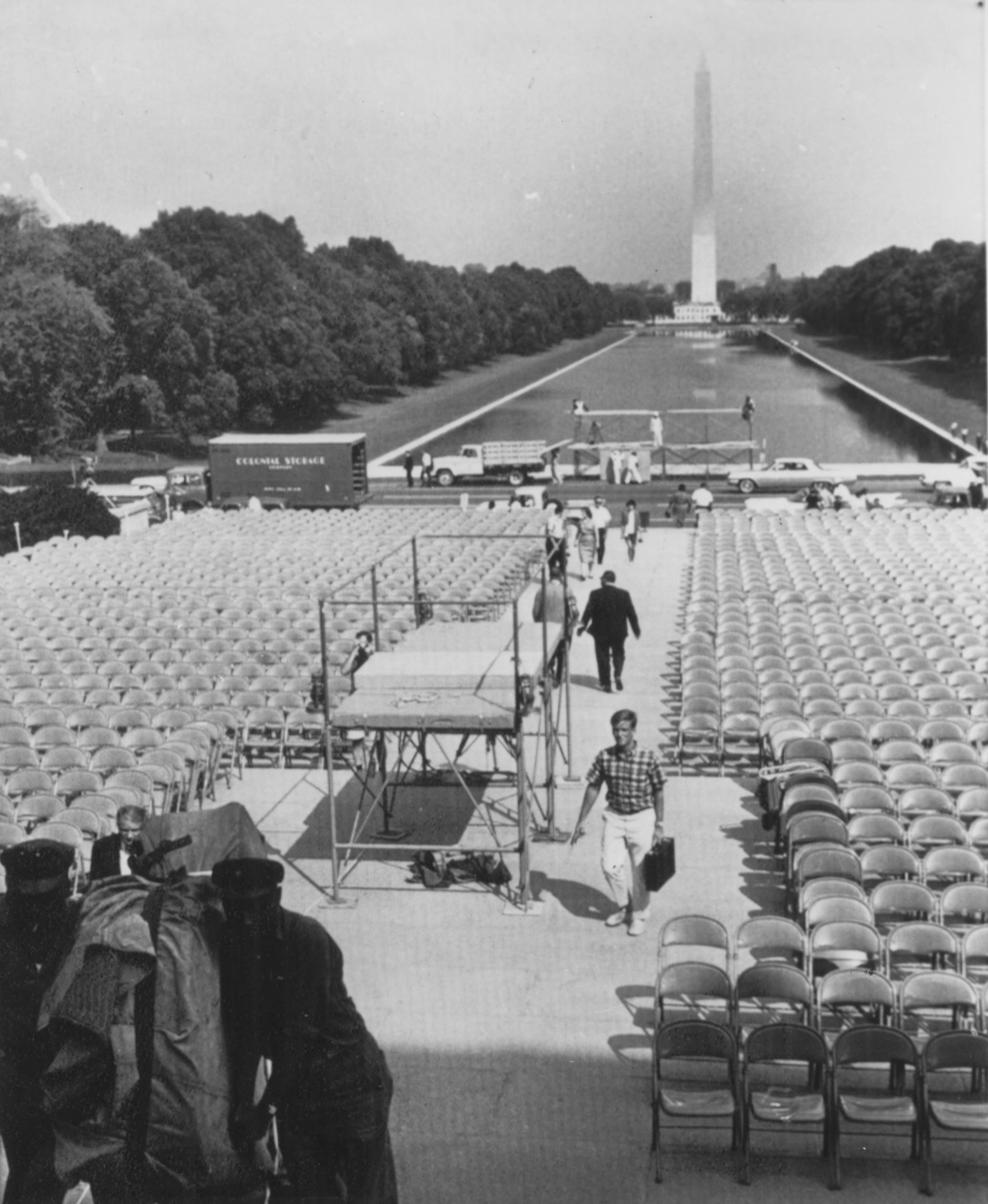 Steps leading to the Lincoln Memorial are packed with chairs for the March on Washington ceremonies the day before the event. The stands are for photo and television coverage of the event. In background is the Reflecting Pool and the Washington Monument. In left foreground, workmen move a piano into the Memorial for use with mass singing. (AP Wirephoto) 1963
