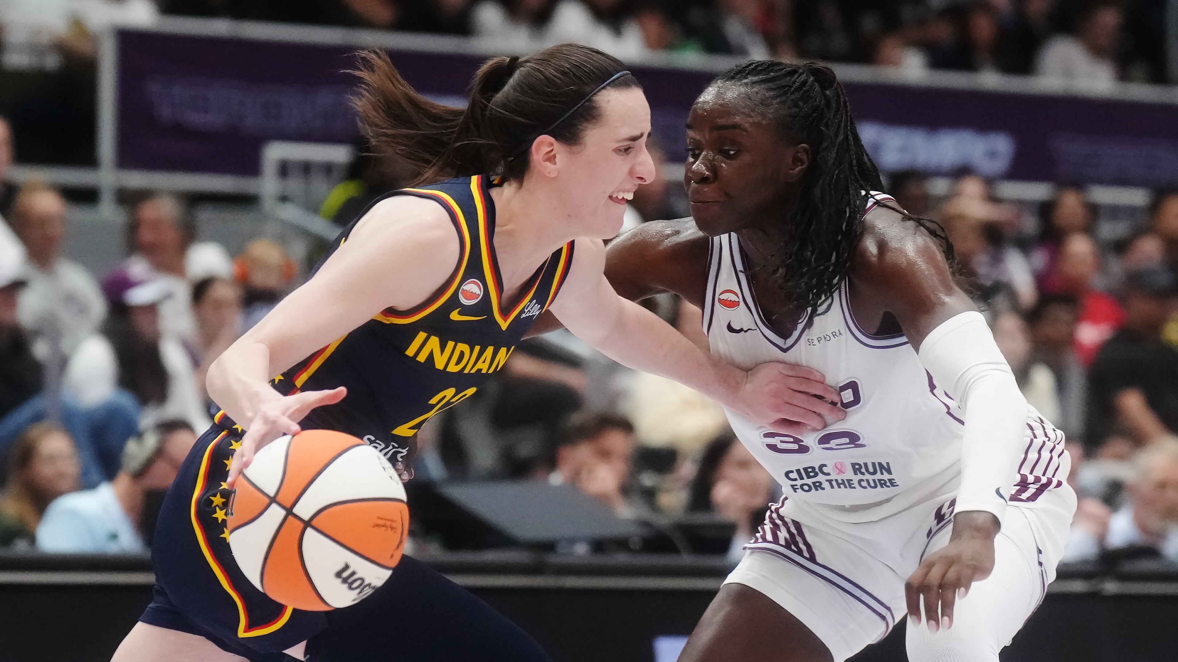 Indiana Fever's Caitlin Clark (22) drives as Toronto Tempo's Ornella Bankole (33) defends during first half WNBA basketball action in Toronto on Friday, Sept. 18, 2026. (Nathan Denette/The Canadian Press via AP)