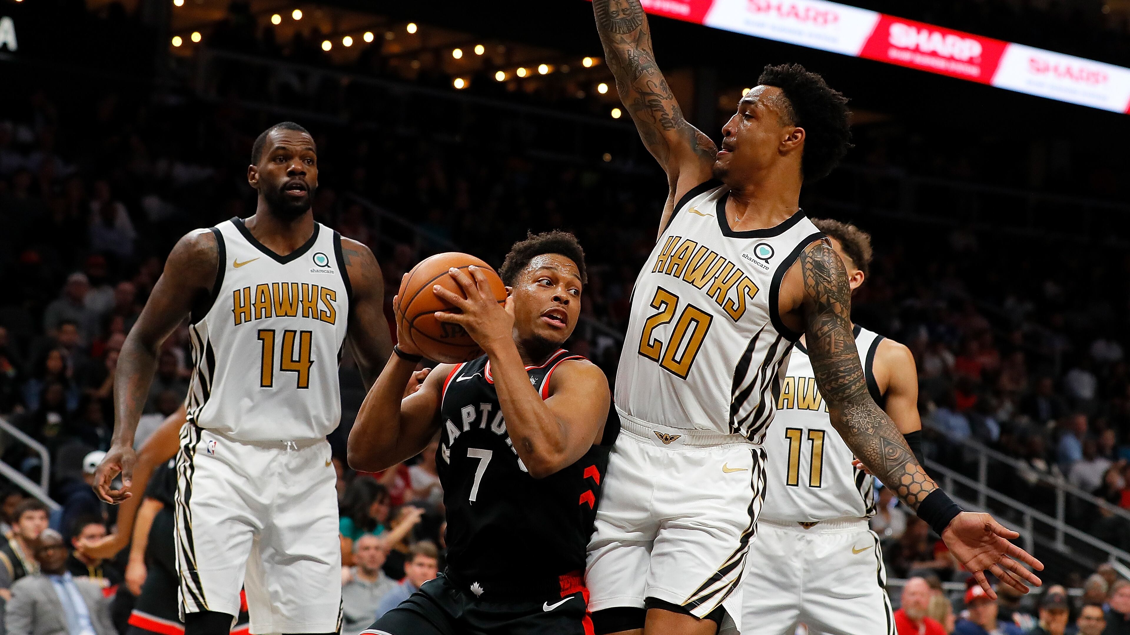 John Collins #20 of the Atlanta Hawks defends against Kyle Lowry #7 of the Toronto Raptors at State Farm Arena. (Photo by Kevin C. Cox/Getty Images)