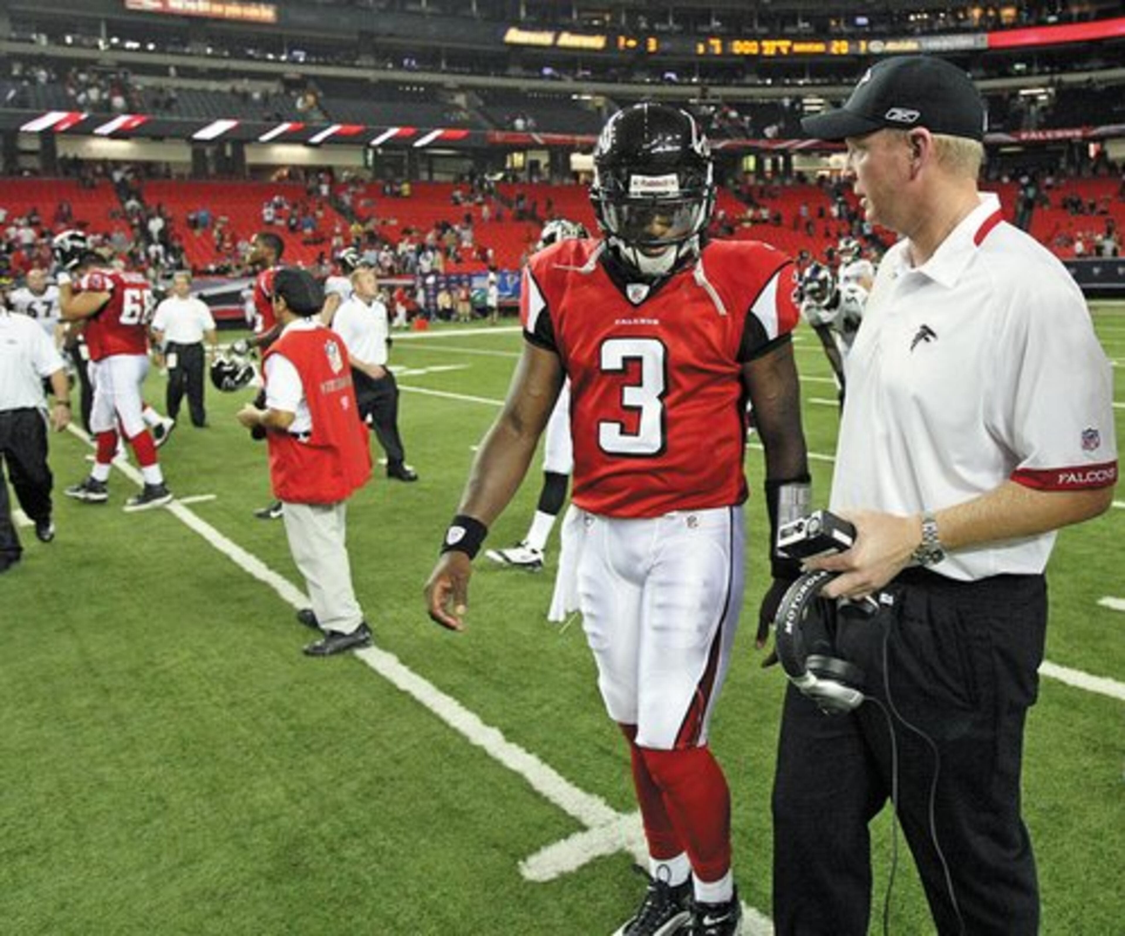 D.J. Shockley talks with quarterbacks coach Bill Musgrave as they walk off the field.