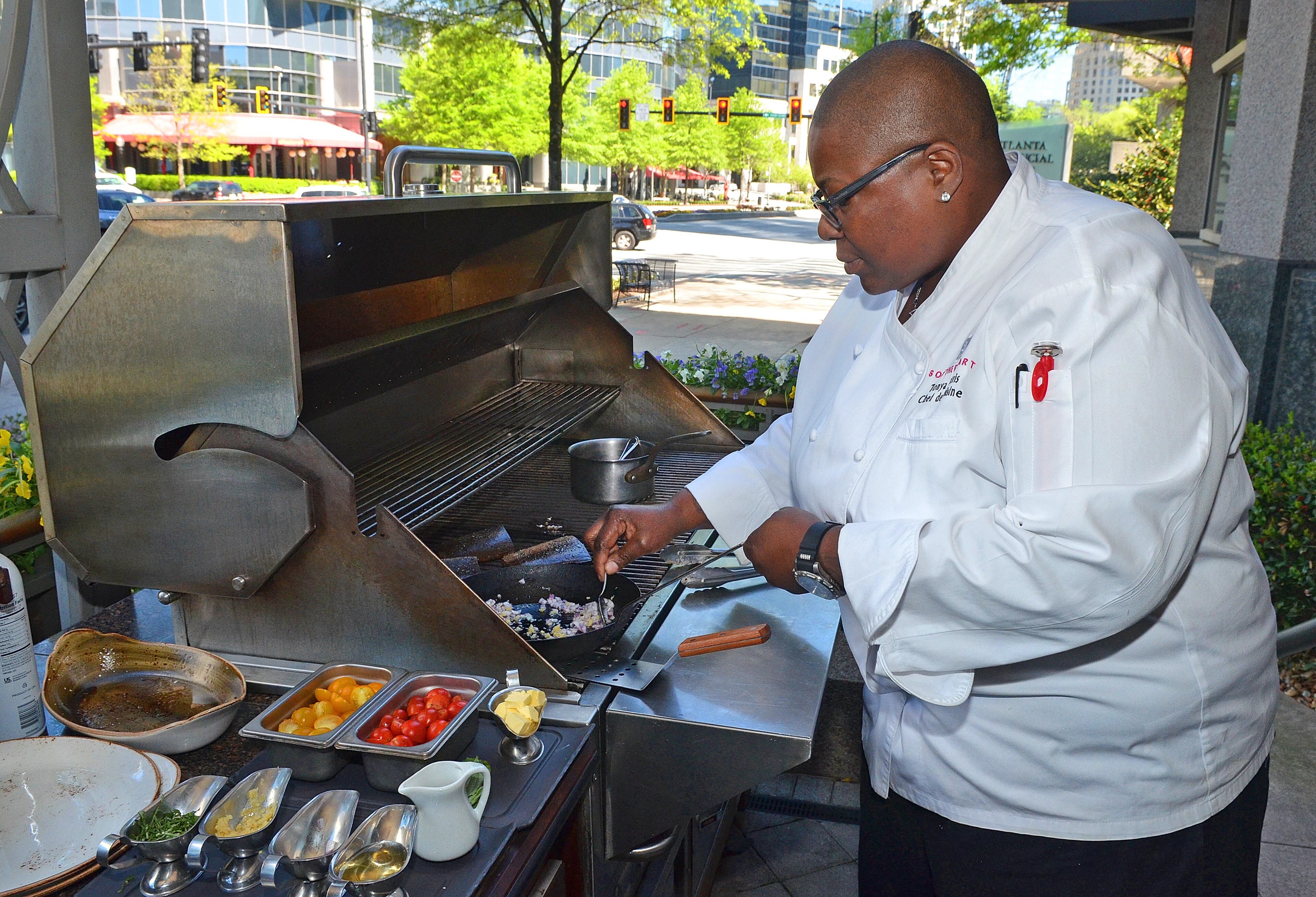 Chef Tonya Morris prepares and grills fresh cobia with black rice and sauteed tomatoes at Southern Art in Buckhead. Photo by Chris Hunt.