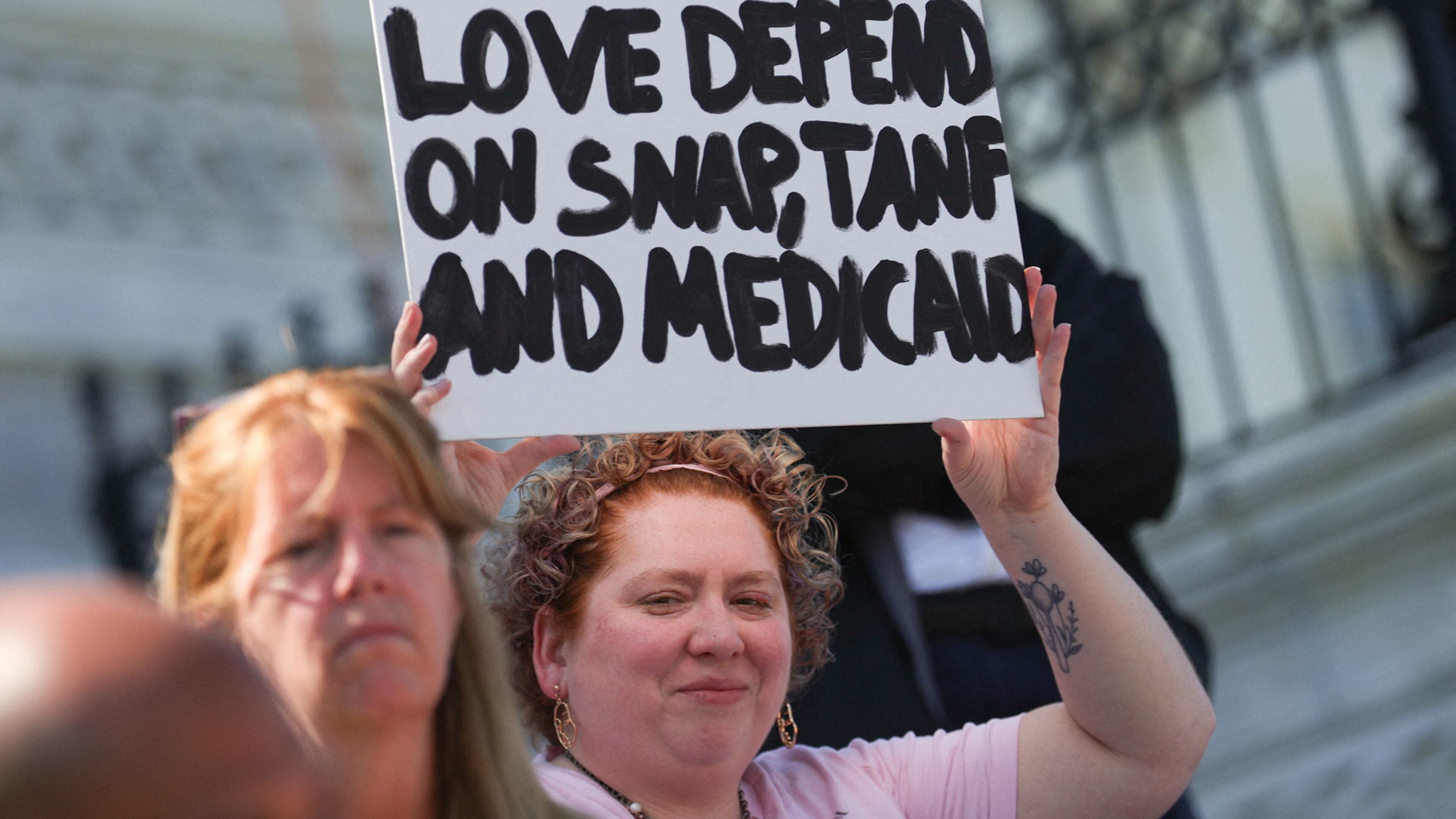 A demonstrator holds a sign reading "People I love depend on SNAP, TANF and Medicaid" during a sit-in protest against a Republican budget plan. (Bryan Dozier/Middle East Images/AFP/Getty Images/TNS)