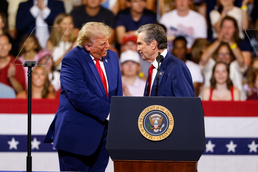 President Donald Trump (left) shakes hands with Republican nominee for governor Rick Jackson at a rally in Marietta on Wednesday. (Arvin Temkar/AJC)