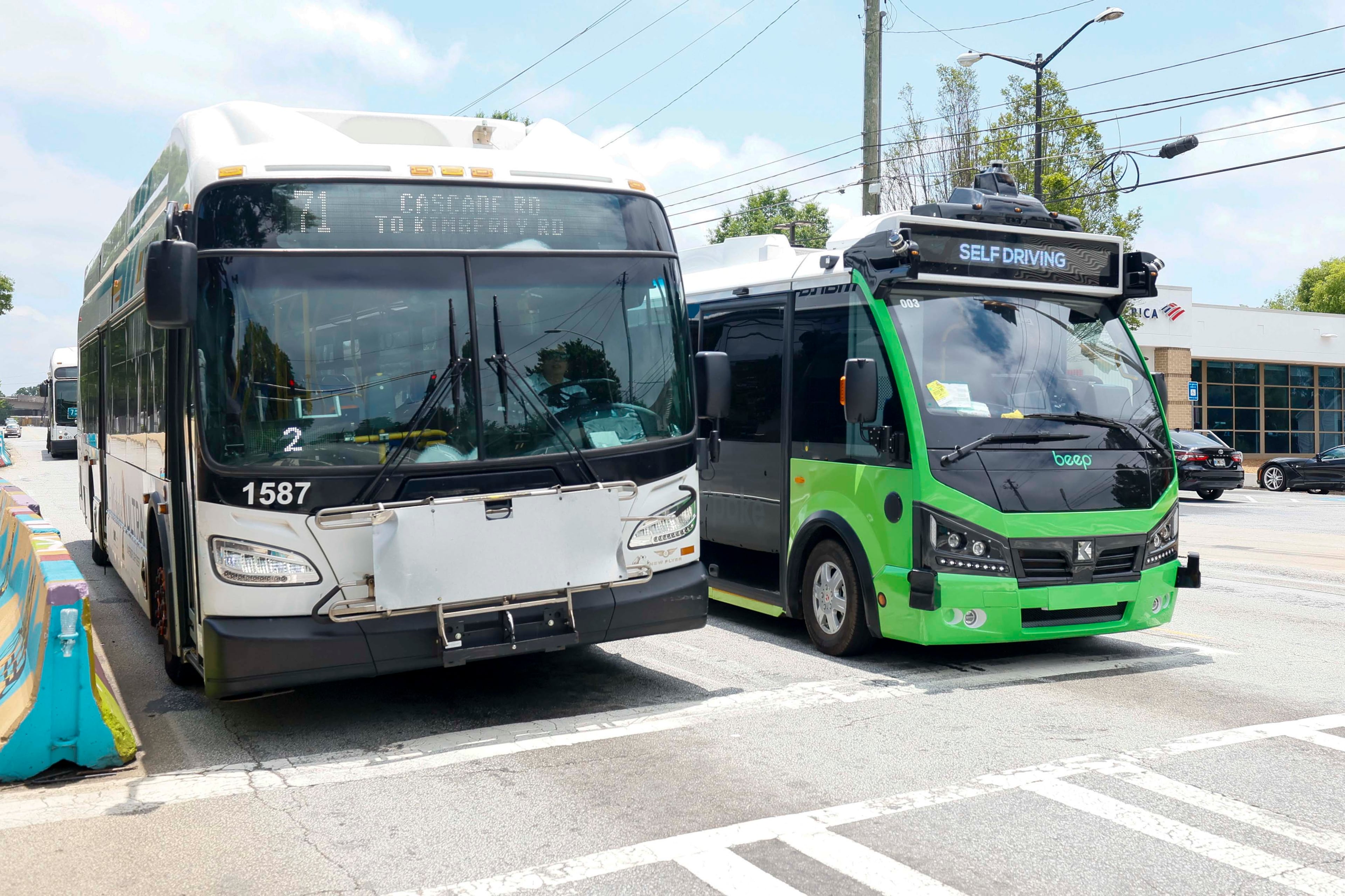 A MARTA bus and an ATL Spoke autonomous vehicle are seen as they depart from the West End MARTA Station on Monday, June 1, 2026. The ATL Spoke, an autonomous pilot program, started offering service recently. It connects the West End MARTA and the Lee + White District. It runs seven days a week. (Miguel Martinez/AJC)