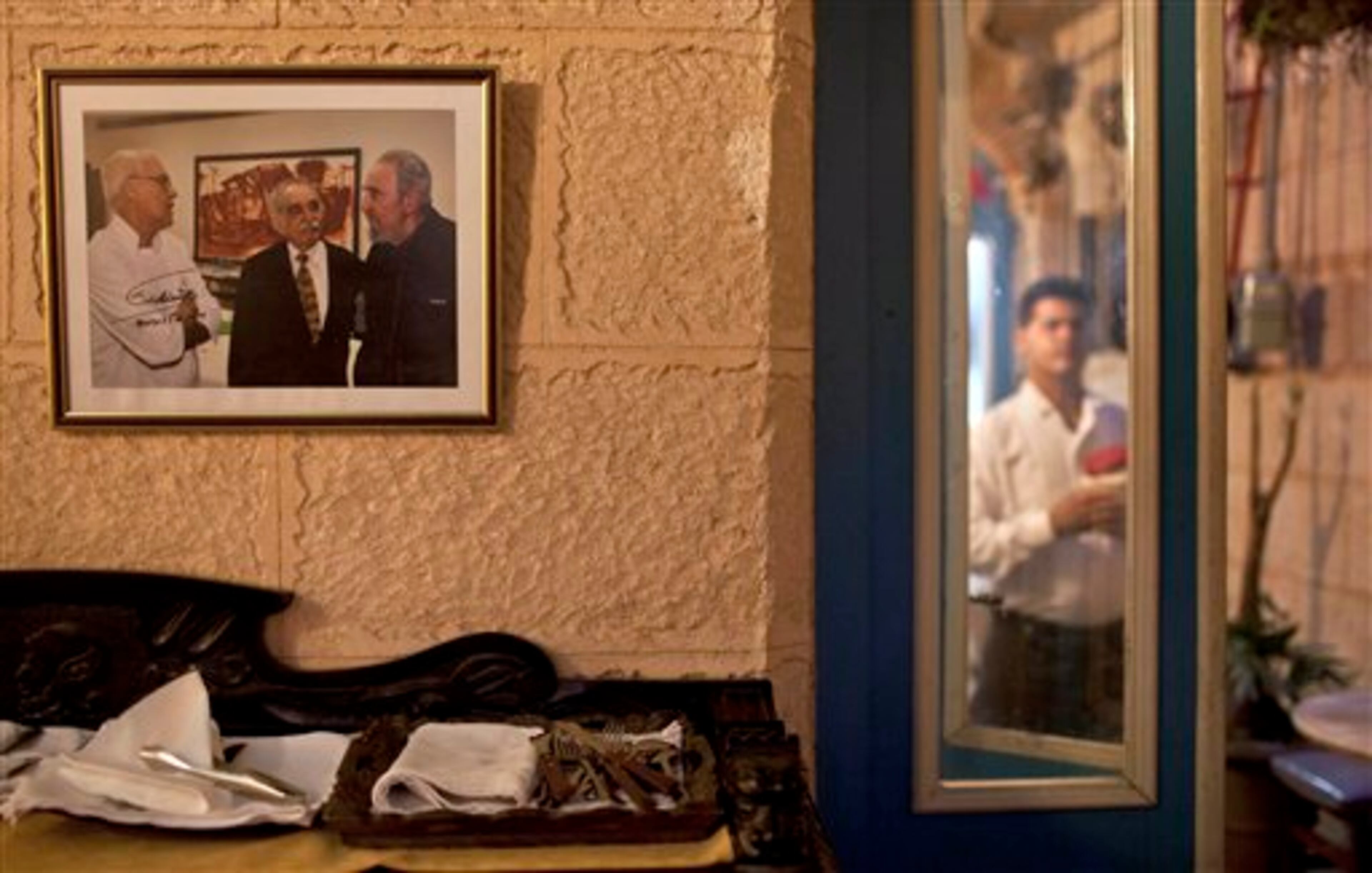 A framed picture of Fidel Castro with Gabriel Garcia Marquez and Tomas Erasmo Hernandez, signed by Castro, hangs inside the private restaurant Mama Ines in Old Havana, Cuba, Thursday, April 17, 2014. Colombian Nobel laureate Gabriel Garcia Marquez died at his home in Mexico City on Thursday. The author's magical realist novels and short stories exposed tens of millions of readers to Latin America's passion, superstition, violence and inequality. (AP Photo/Franklin Reyes)
