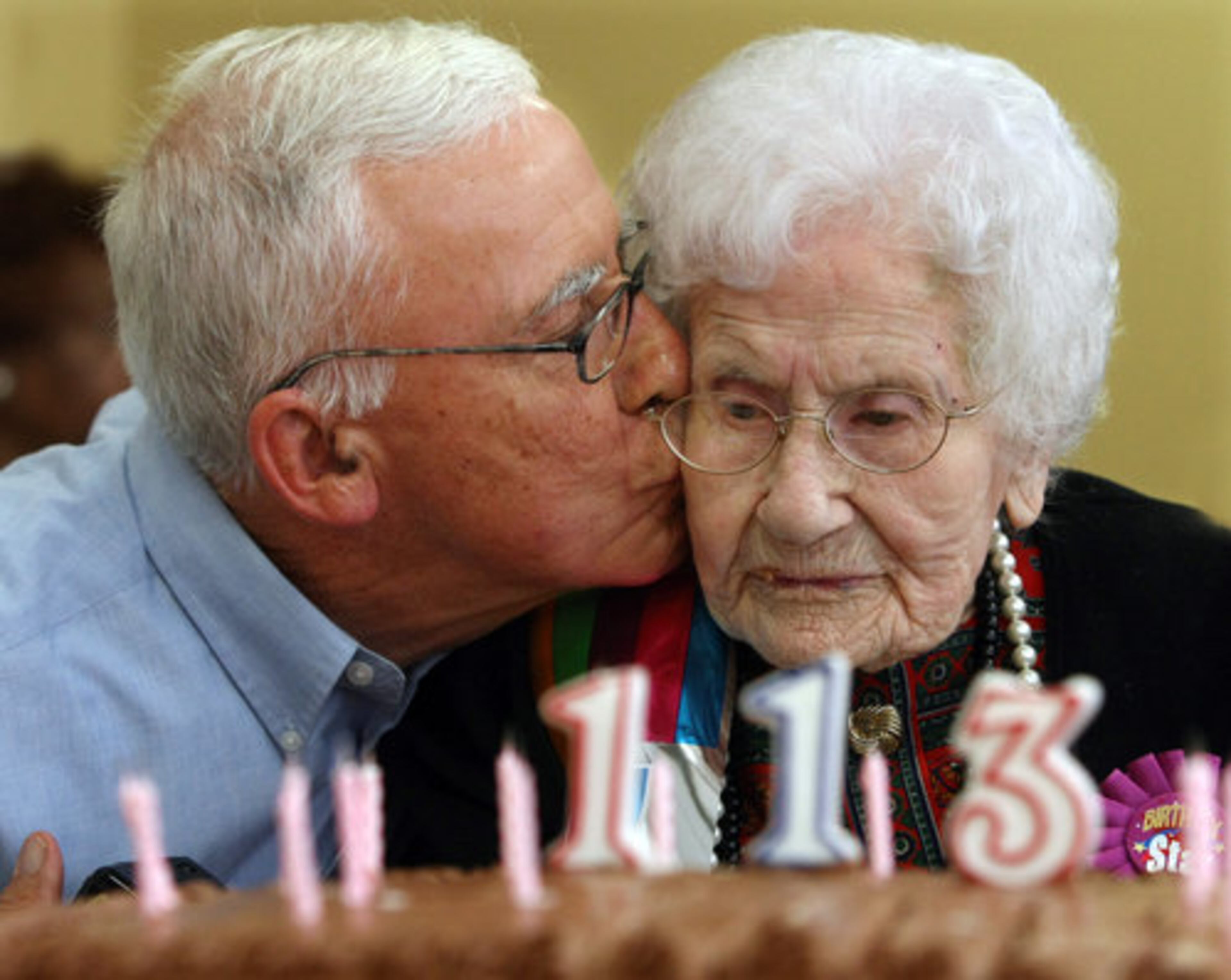 Sidney Cooper, 74, of Monroe, gives his mother Besse Cooper a kiss after she blows out the candles on her cake.
