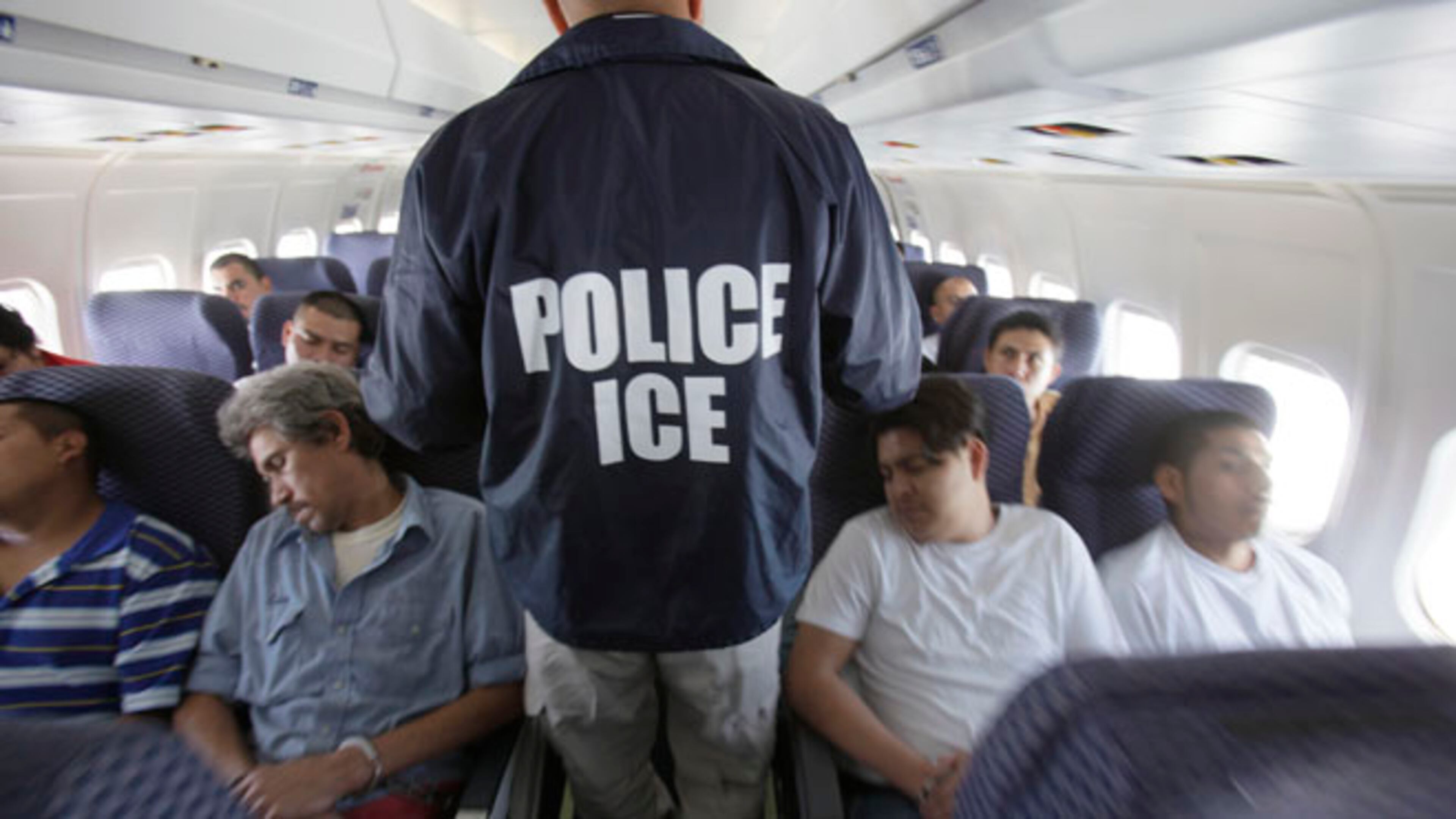 File photo--An Immigration and Customs Enforcement agent walks down the aisle among shackled Mexican immigrants a boarded a U.S. Immigration and Customs Enforcement charter jet for deportation. May 25, 2010. (AP Photo/LM Otero)