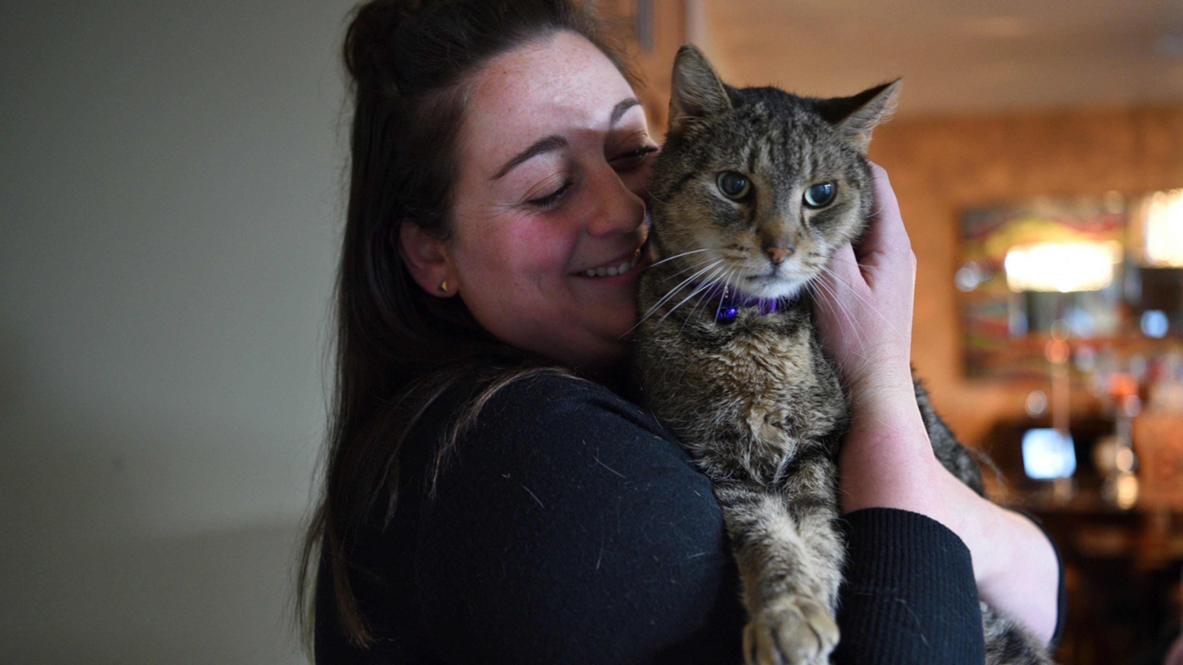 Paige Zelitsky, 23, snuggles with Jimmy, a brown tabby, on Tuesday, April 4, 2017 in Wanaque, N.J. The cat disappeared after being let out of its Wanaque home on Sept. 13, 2014. The West Milford Animal Shelter Society says Jimmy was found in the town's High Crest section during the March blizzard. (Amy Newman/The Record via AP)