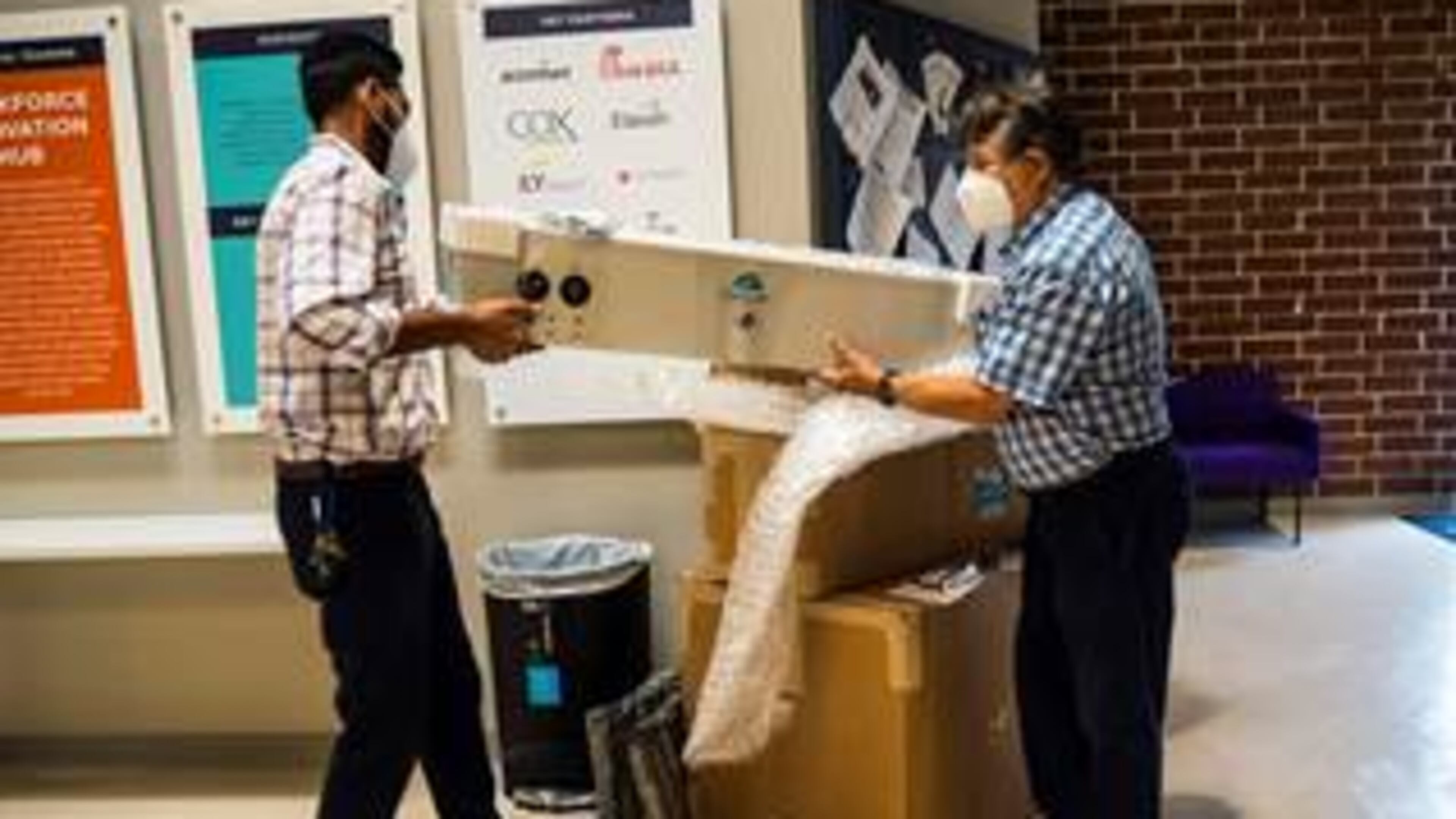 Faizan Aly, managing director (L) and Co-founder of Aguair Itamar Kleinberger unpacking the donated equipment, their SaniCart and the ClensAir.