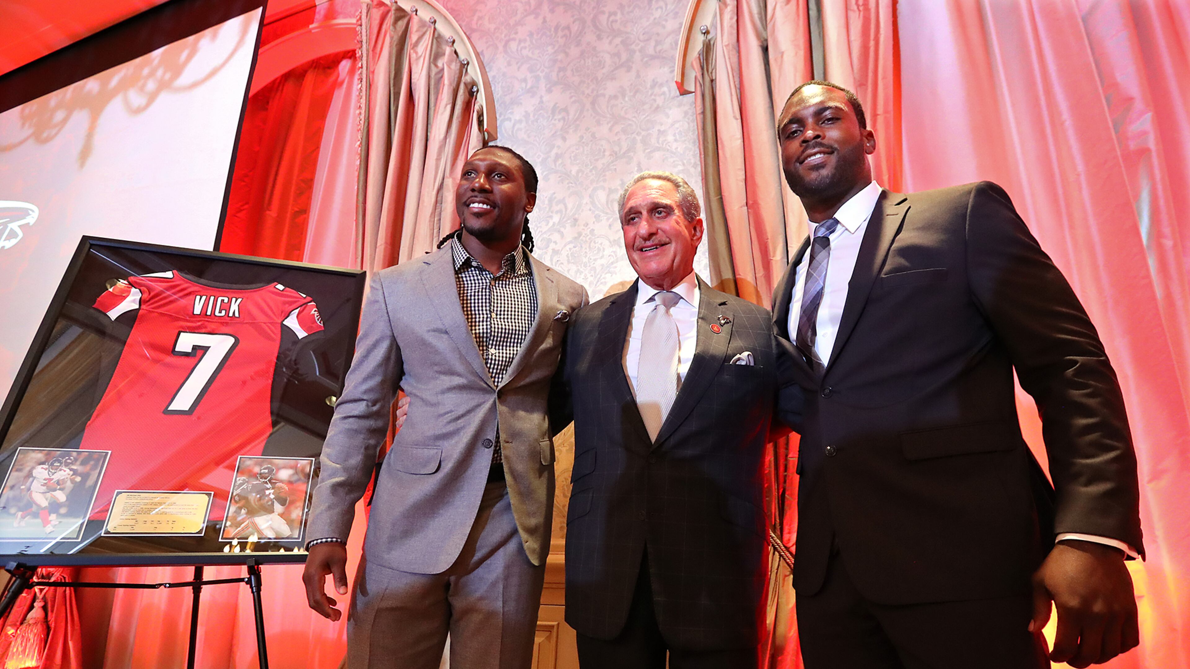 Atlanta Falcons owner Arthur Blank honors former Falcons quarterback Michael Vick (right) and wide receiver Roddy White as they officially retire from the NFL on Monday. (Curtis Compton/ccompton@ajc.com)