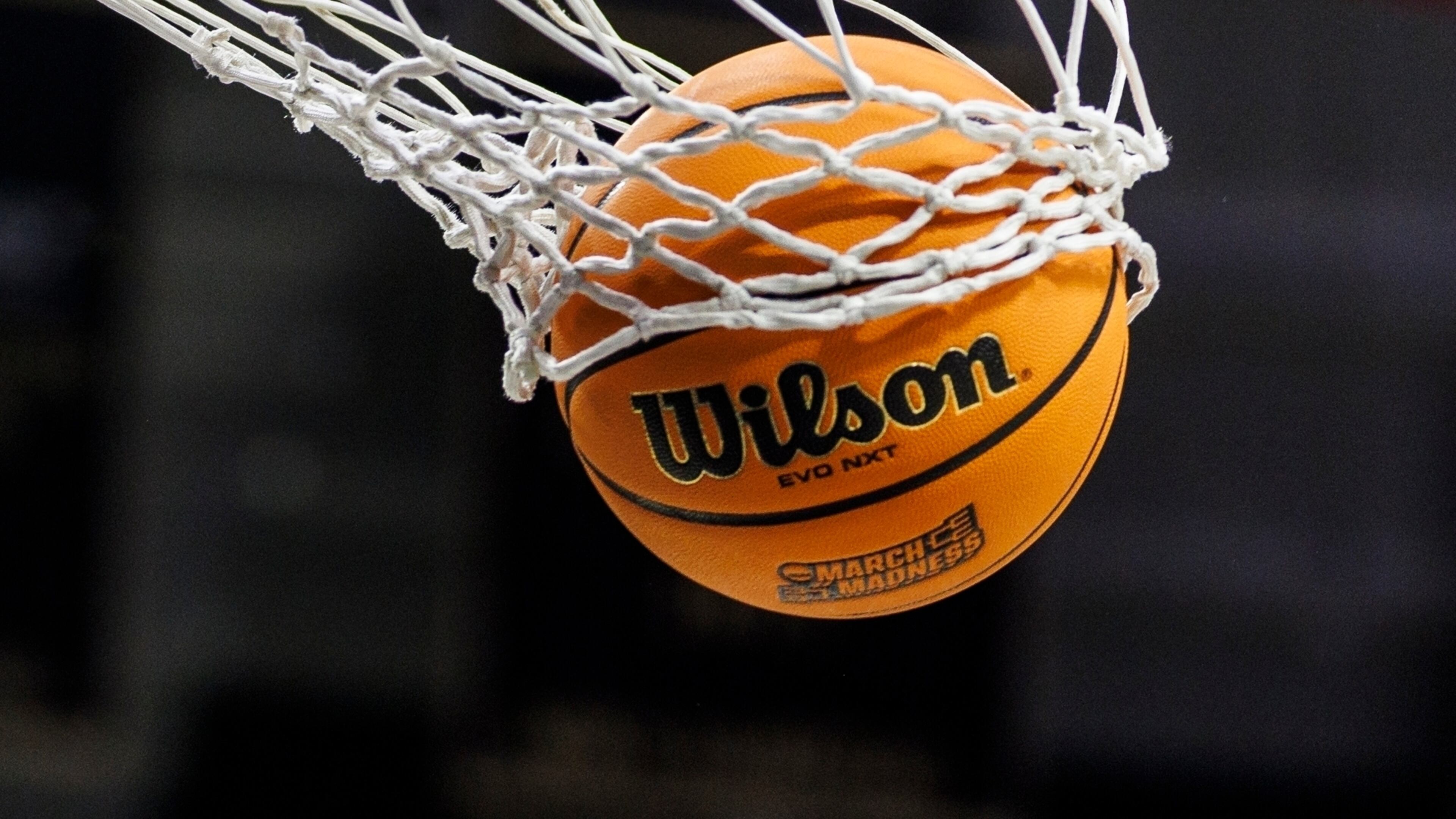 FILE - A basketball with a March Madness logo is seen going through a net prior to a second round of the NCAA college basketball tournament between Notre Dame and Michigan, March 23, 2025, in South Bend, Ind. (AP Photo/John Mersits, File)