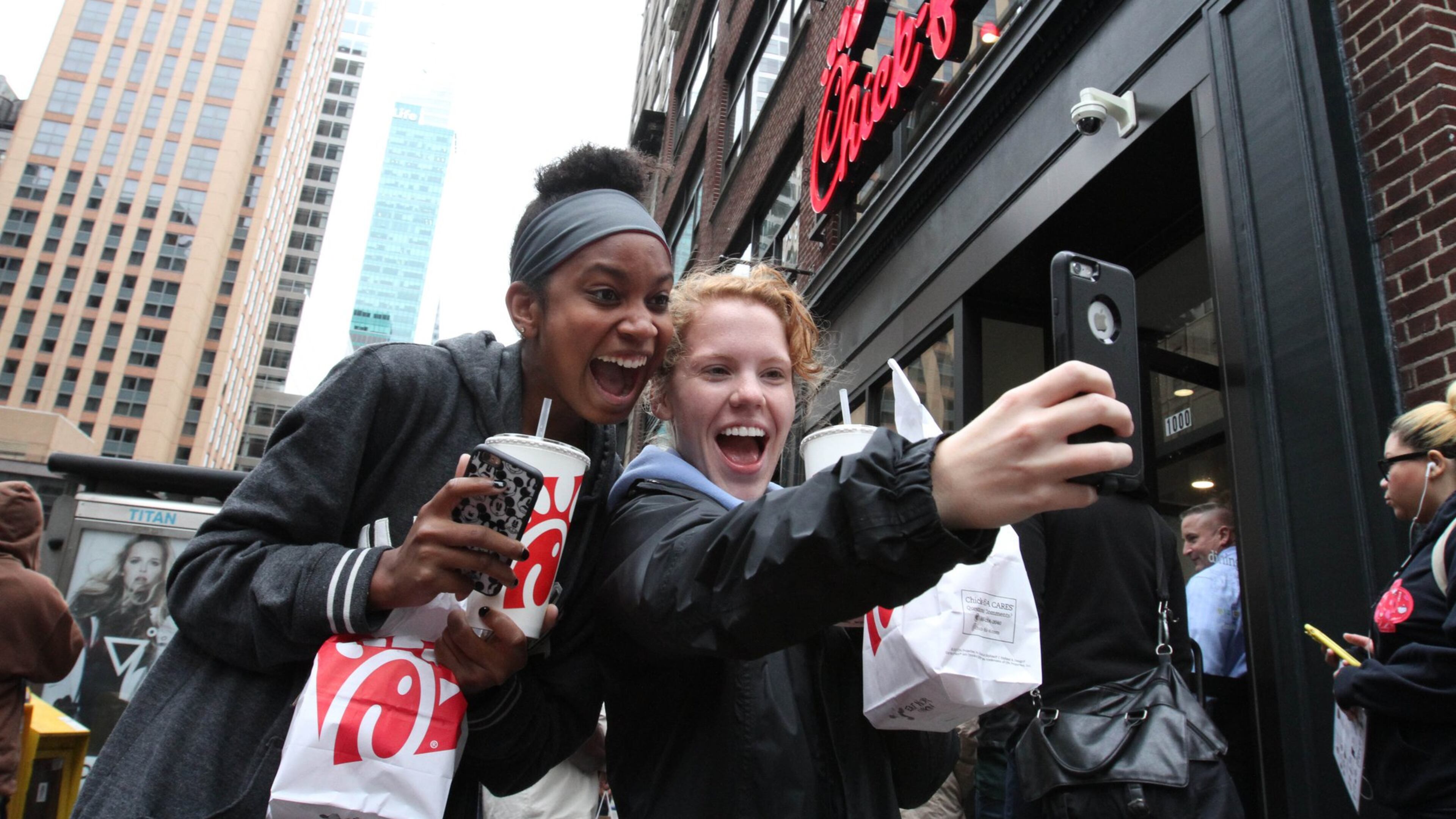 Jaimie Cranford, right, takes a photograph with Mariah Reives outside the Chick-fil-A store in New York on the store’s opening day. Cranford, originally from South Carolina, and Reives, originally from North Carolina, currently live in New York. (AP Photo/Tina Fineberg)