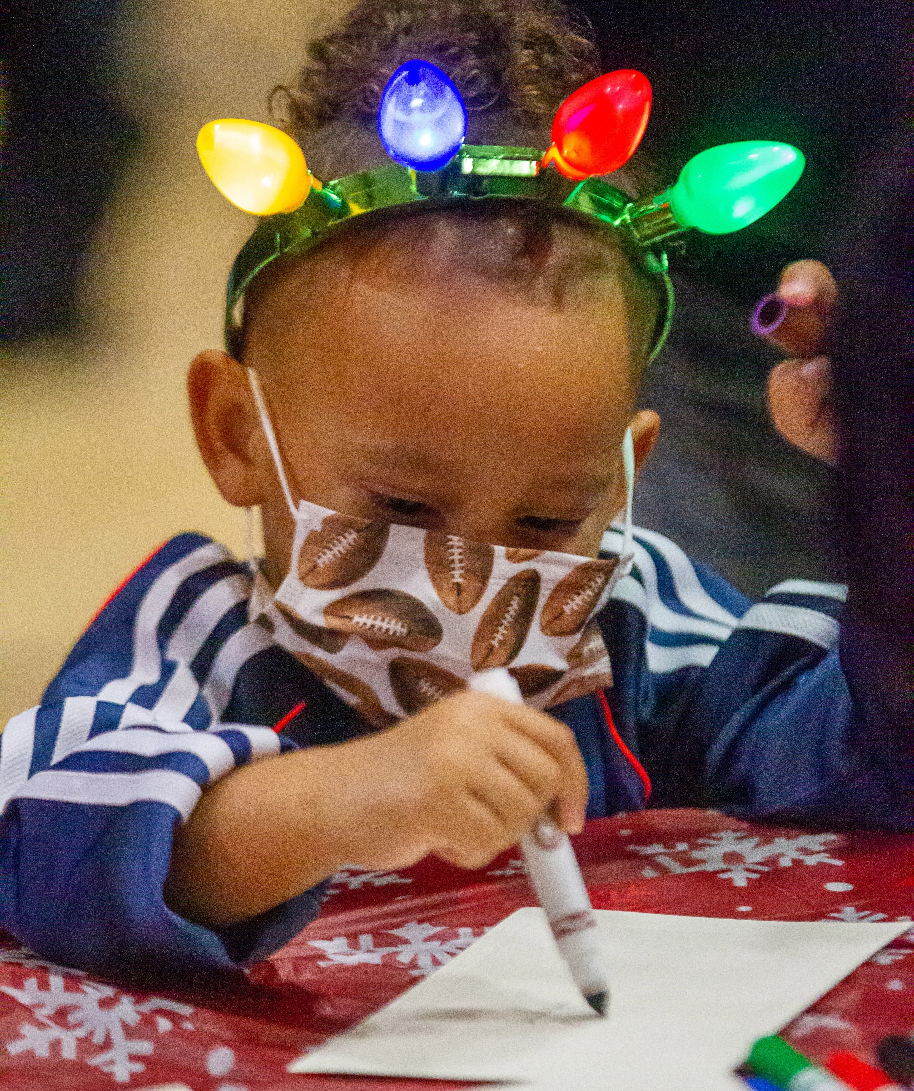 Chane Barringer, 2, writes Santa a letter during the Doraville sesquicentennial grand finale celebration at the Forest Fleming Arena on Saturday, December 11, 2021. STEVE SCHAEFER FOR THE ATLANTA JOURNAL-CONSTITUTION
