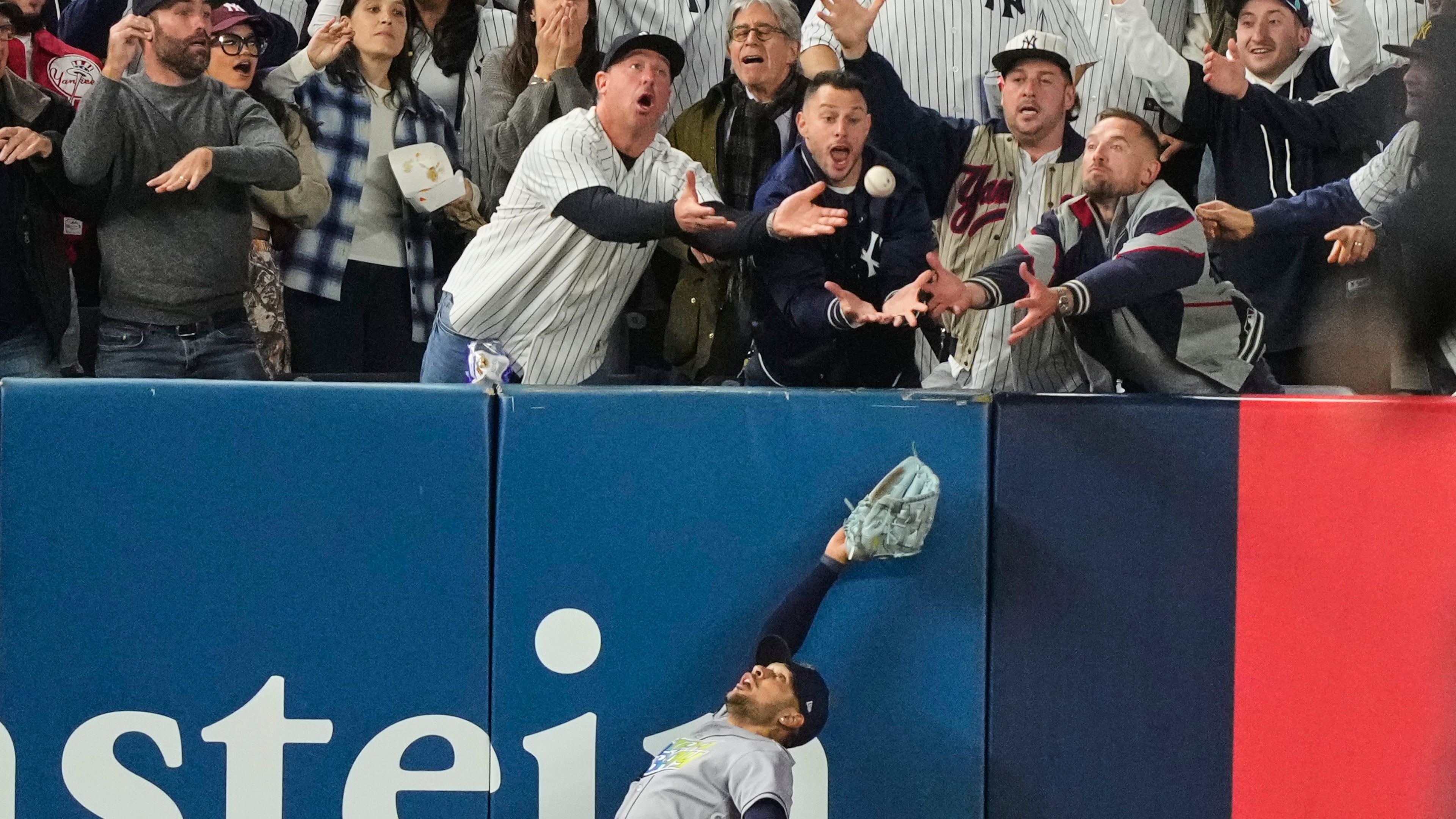 Tampa Bay Rays left fielder Victor Mesa Jr. makes an attempt on a ball interfered with by fans that umpires reviewed and ruled a run-scoring double by New York Yankees' Anthony Volpe during the sixth inning in Game 3 of baseball's American League Division Series, Wednesday, Oct. 7, 2026, in New York. (AP Photo/Yuki Iwamura)