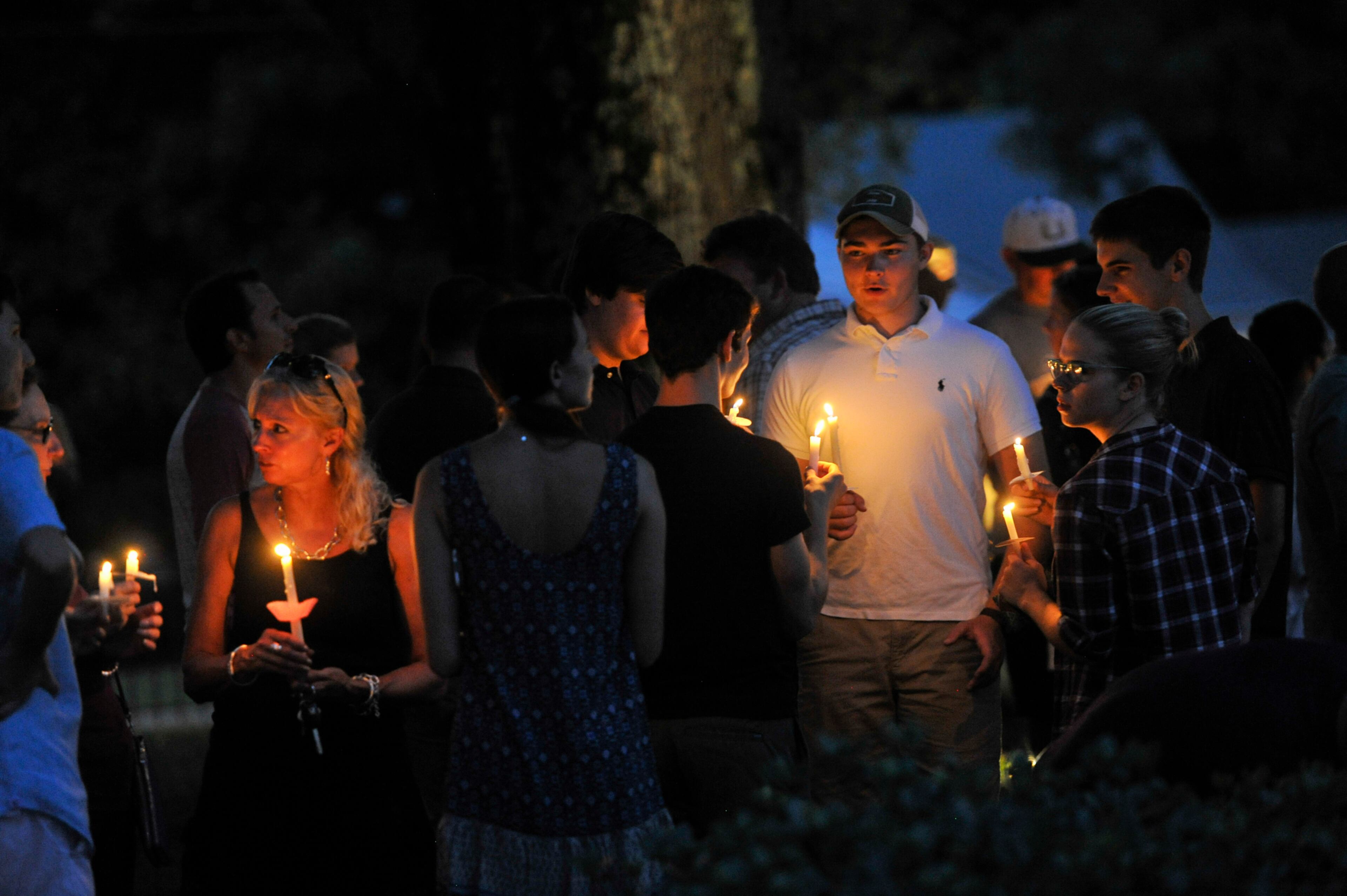 Friends of Natalie Henderson hug during a vigil held for her on the old Roswell Square, Thursday, Aug. 4, 2016. Henderson, of Roswell, and Carter Davis of Woodstock, both 17, were found Monday behind a Publix grocery store shot to death. Jeffrey A. Hazelwood, 20, was arrested Wednesday and will be charged with two counts of murder in the deaths. (Photo Contributed by John Amis)